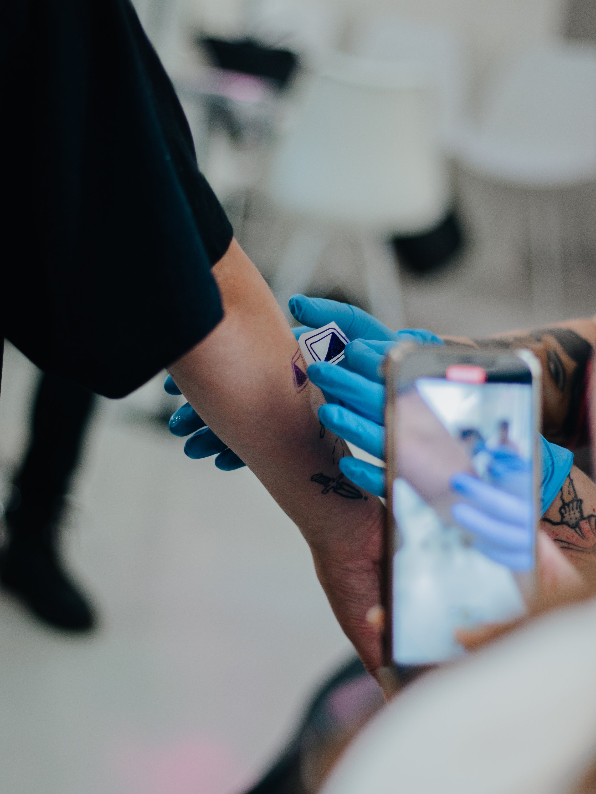Persoon krijgt een tattoo gezet op haar arm in een kliniek.
