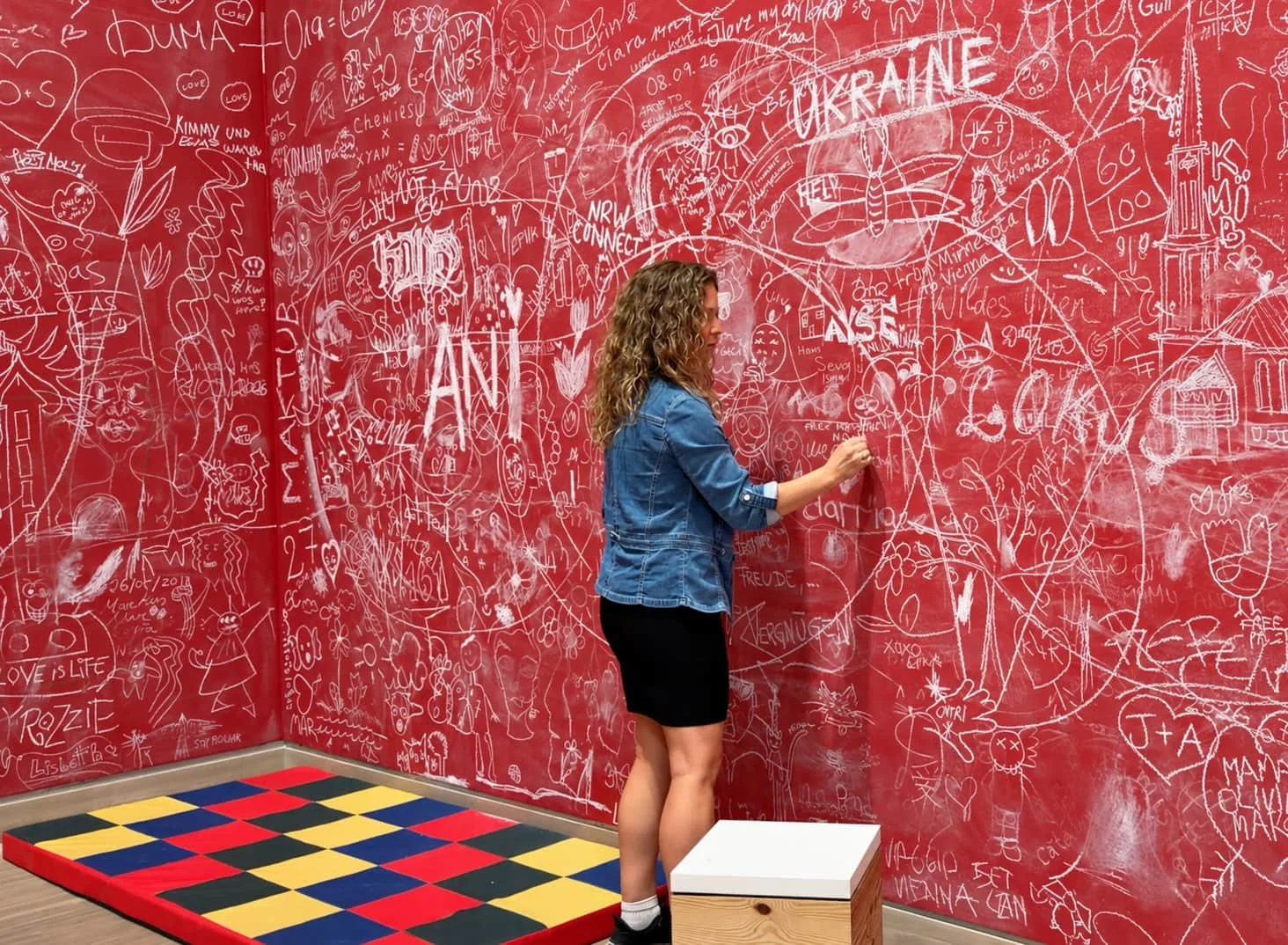 Woman beside a vibrant red chalk wall-1.jpg