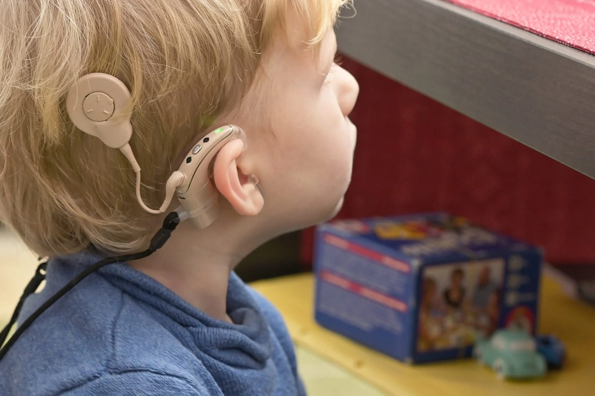 Gros plan sur l'oreille d'un enfant portant un implant cochléaire