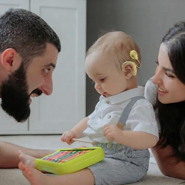 Parents et bébé portant un implant cochléaire en séance de jeu, module 3 Introduction à l'AVT