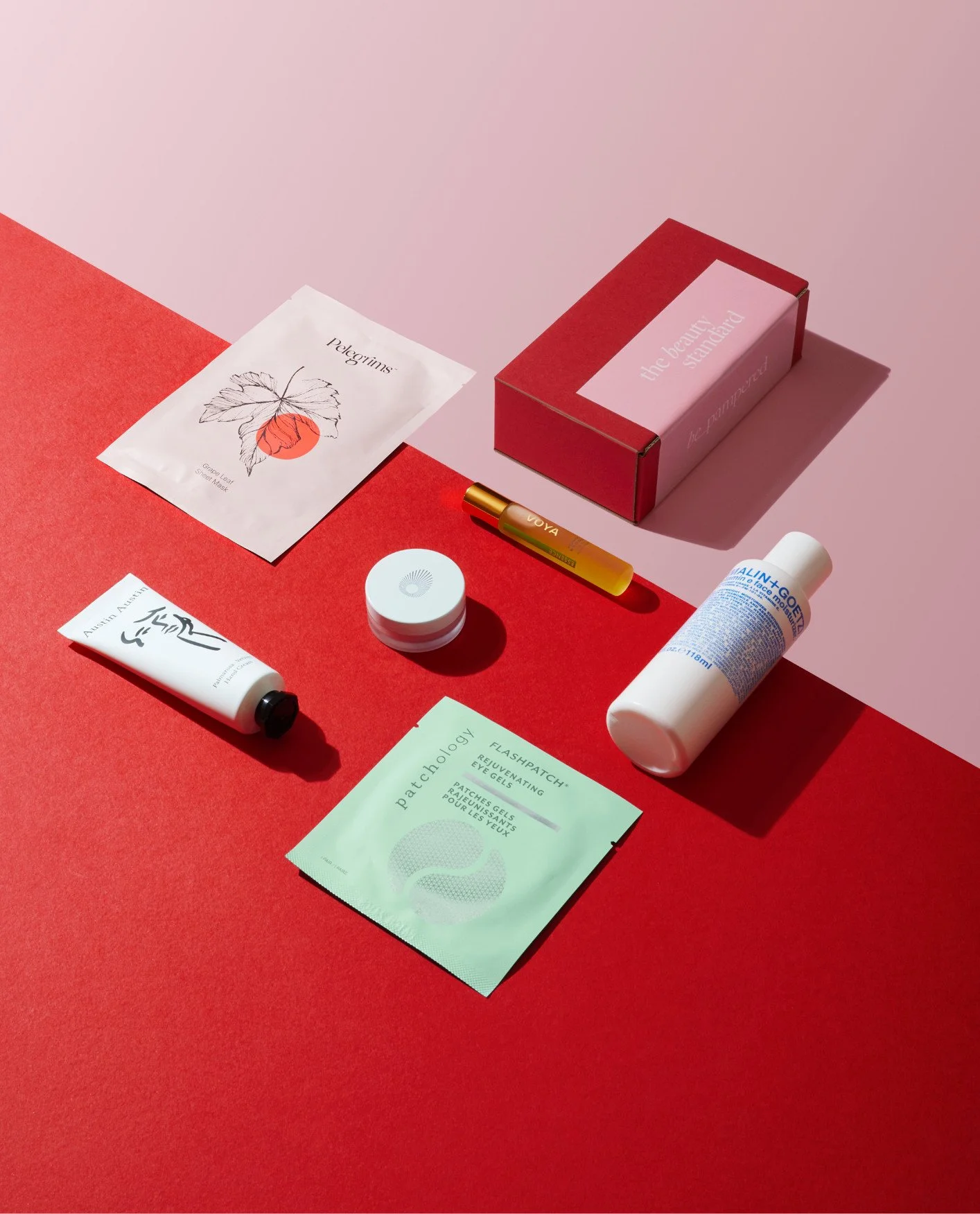 Virgin Atlantic beauty wellness box flatlay against a red and pink background
