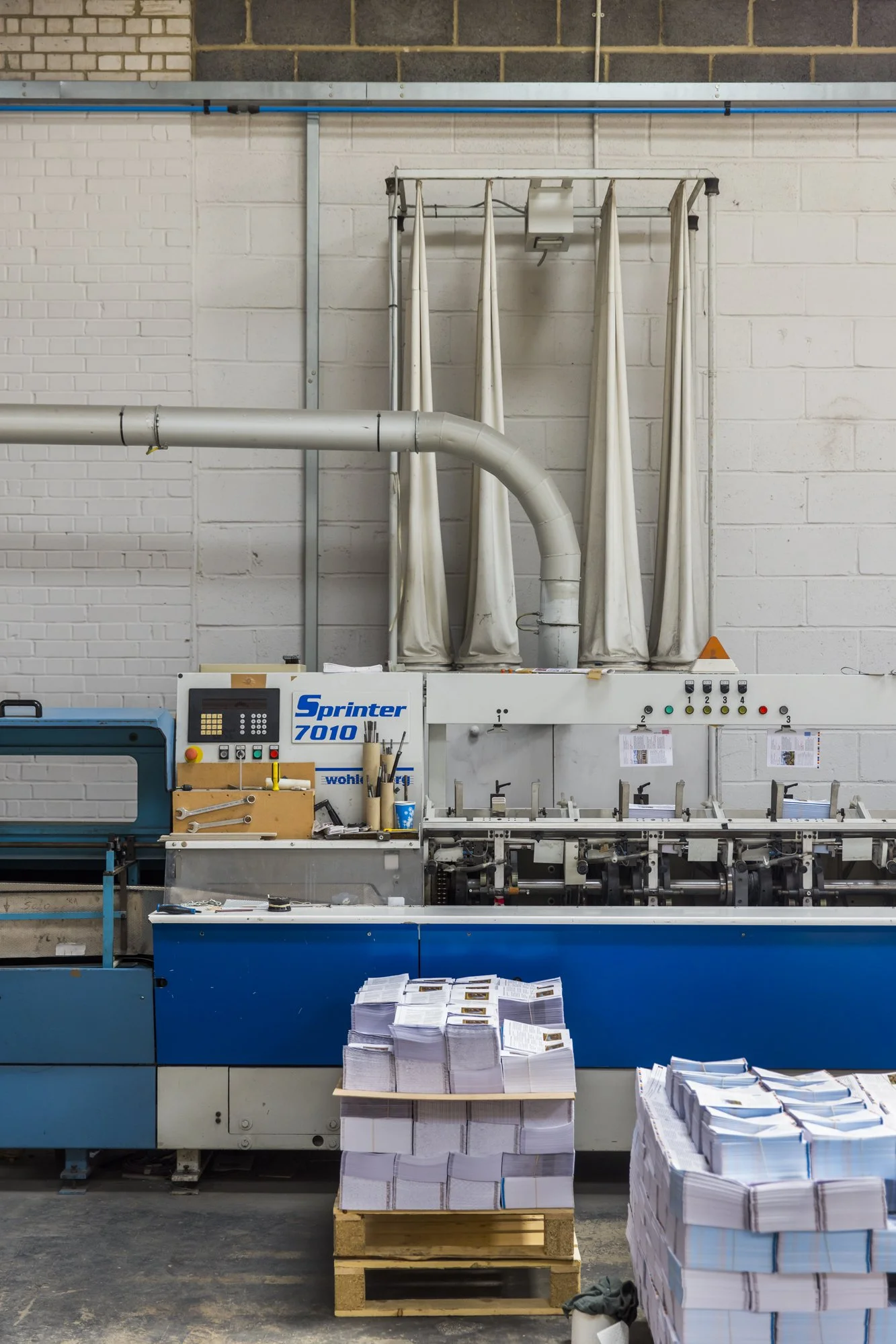 Pallets of paper in front of a commercial printer