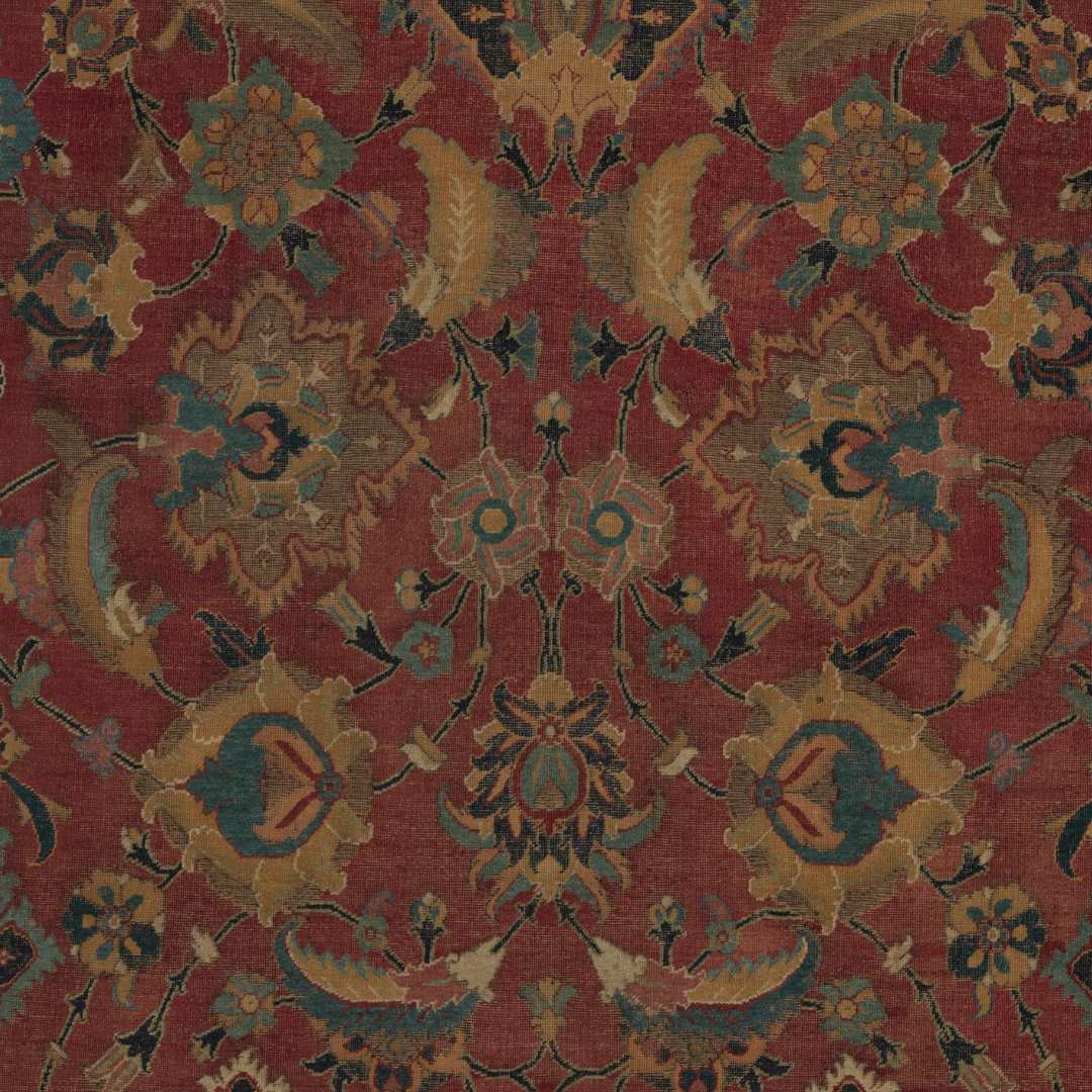 A detailed, traditional Persian-style rug with floral and leaf motifs in shades of red, gold, teal, and black.