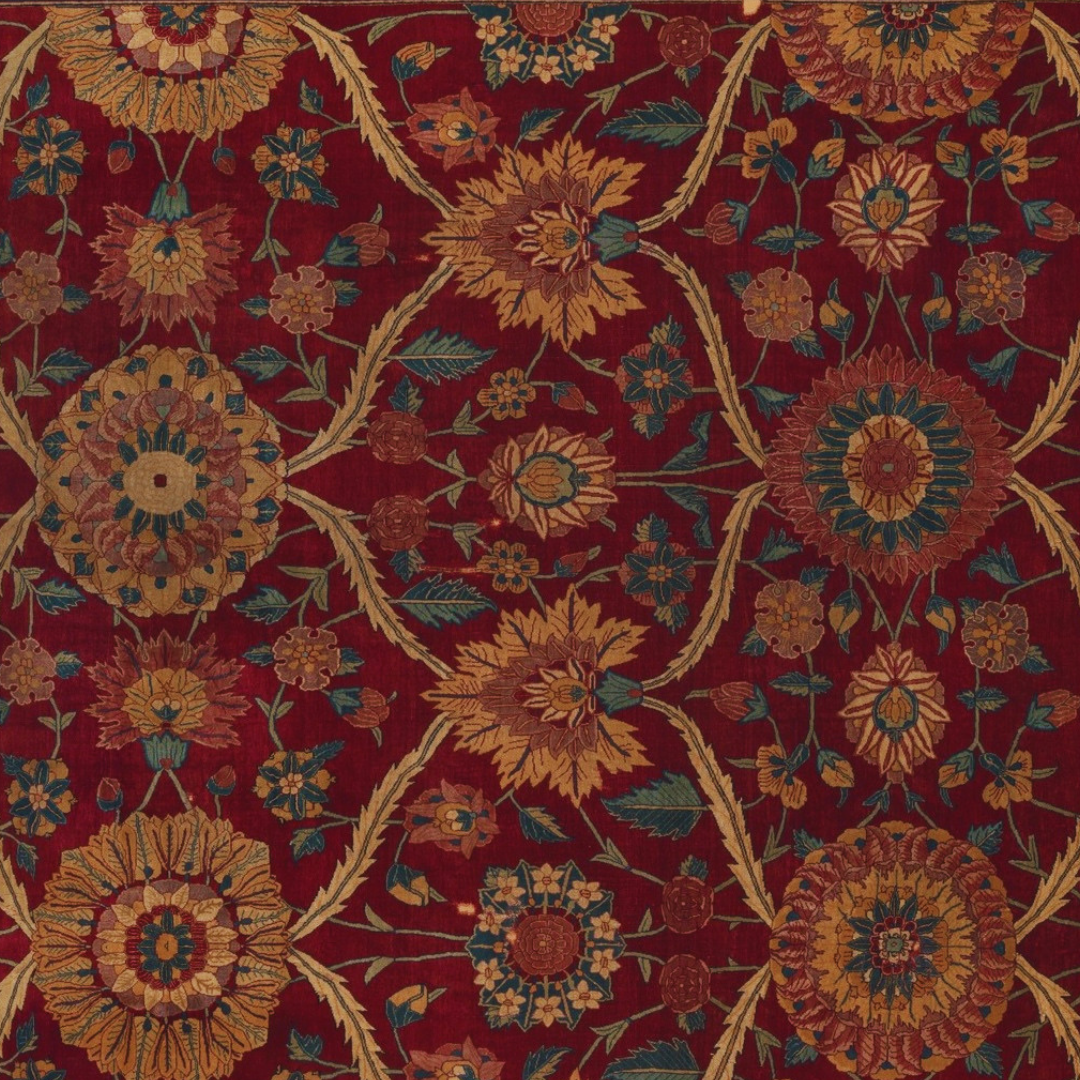 Close-up of a red patterned Persian rug with floral motifs in yellow, blue, and green.