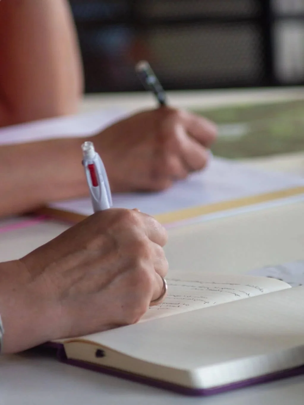 Close-up of a participant writing in a notebook during the workshop.