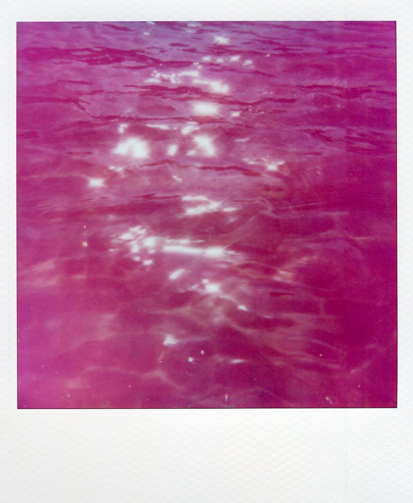 Detail of Water Mark (Baltic Sea) I, showing rippling pink seawater with bright reflections of sunlight.