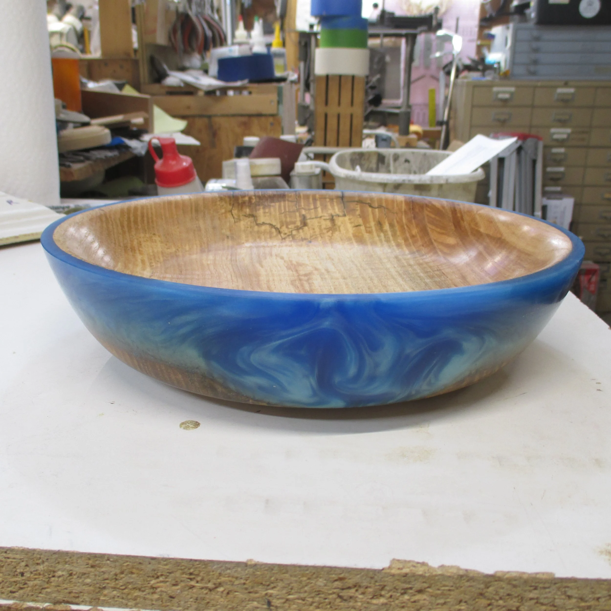 Handcrafted wood and resin bowl by Art by Herb, featuring a blue exterior and warm golden-brown interior.