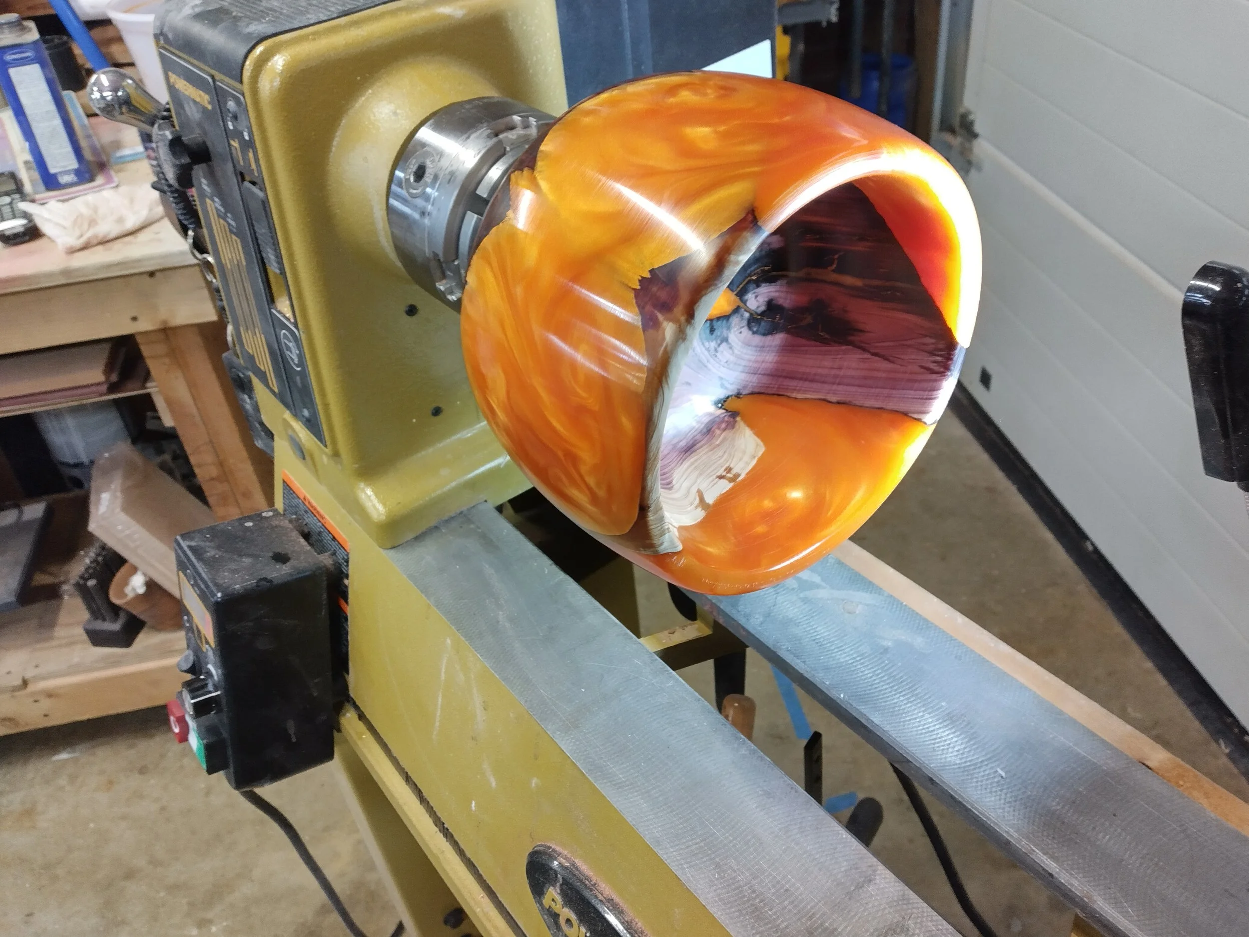 Handcrafted wood and resin piece by Art by Herb, shown on the lathe during the turning process.
