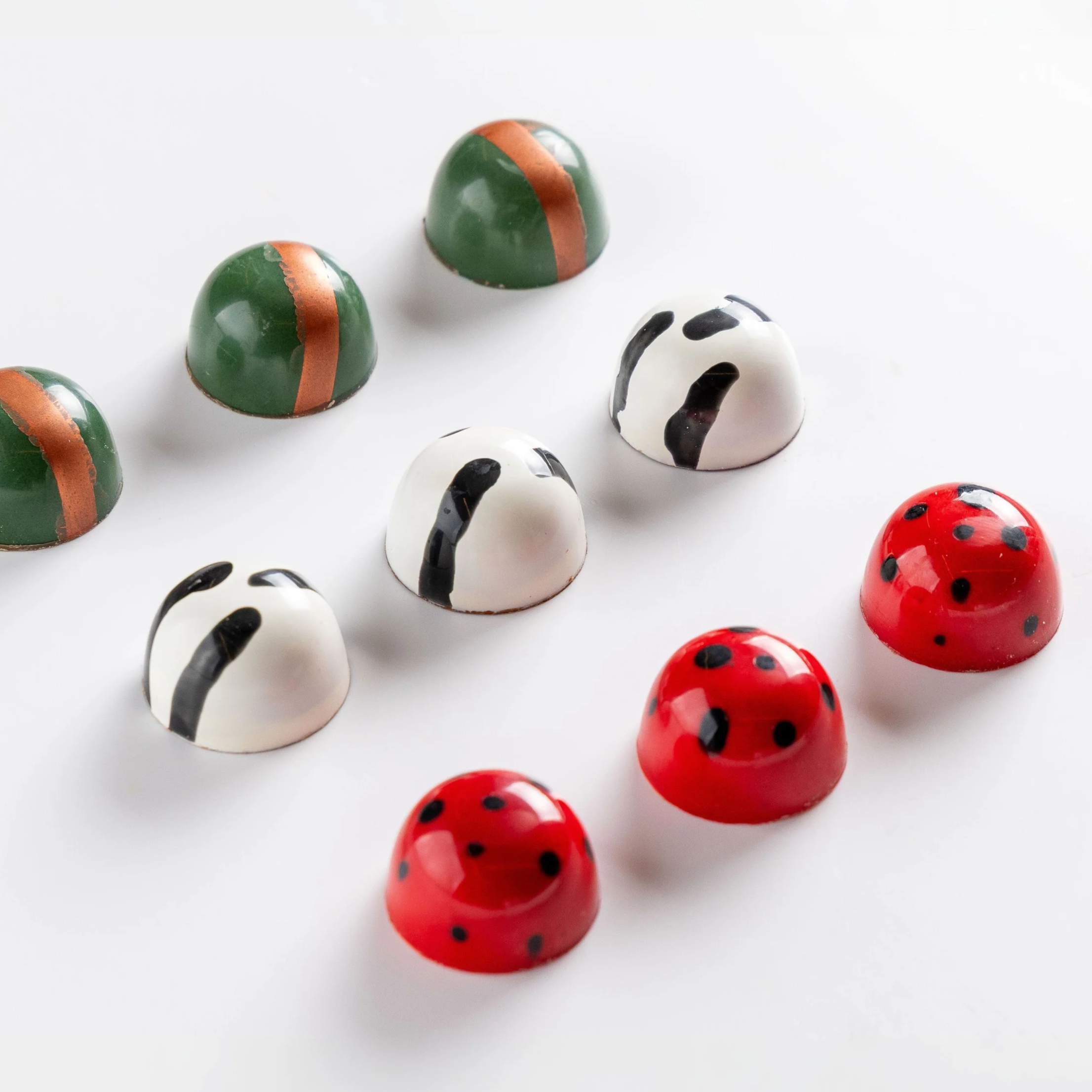Seleção de bombons personalizados da Ahto Pâtisserie com diferentes cores e acabamentos para eventos e projetos especiais.