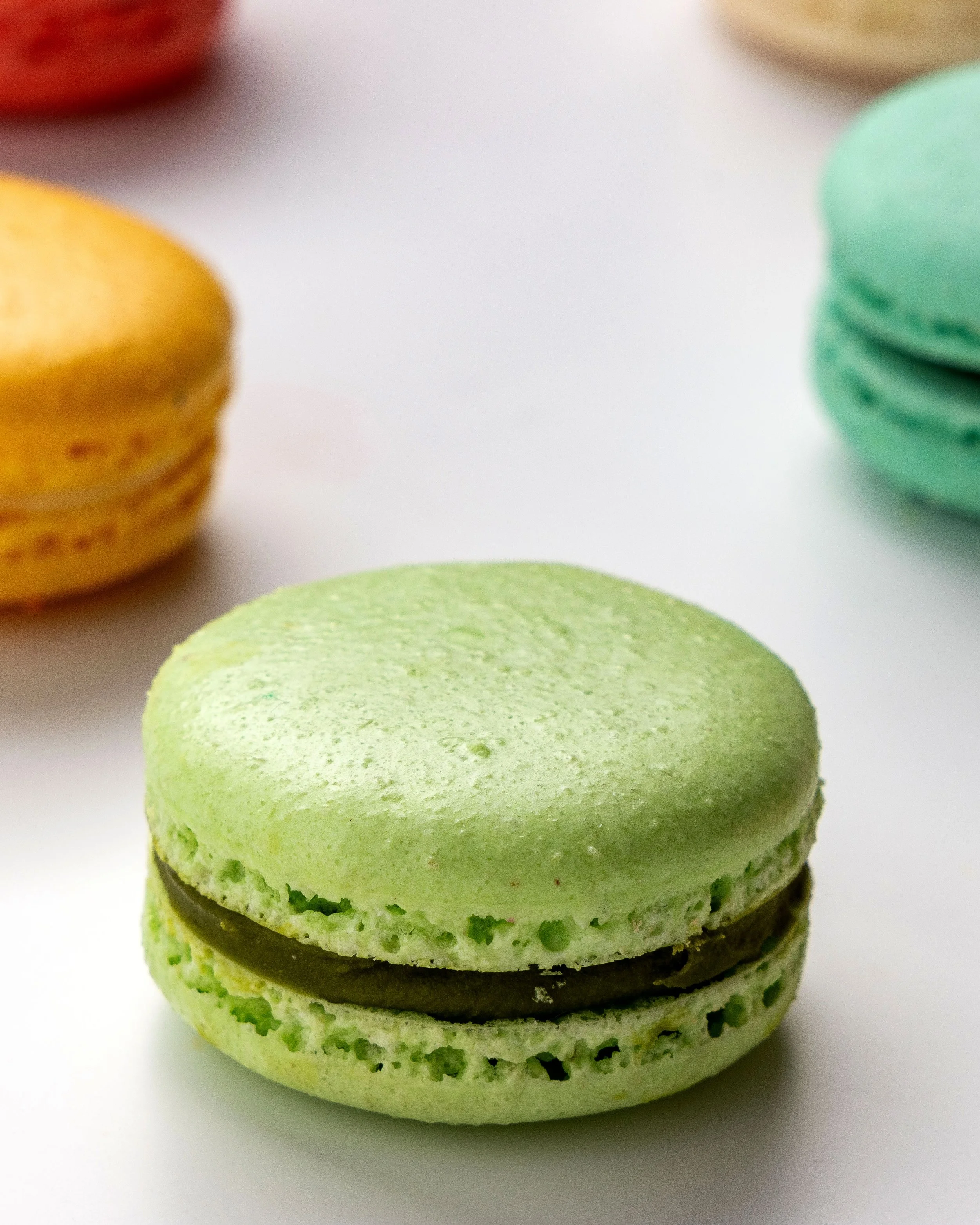 Macaron de matcha da Ahto Pâtisserie, com cascas verdes e recheio de chocolate.