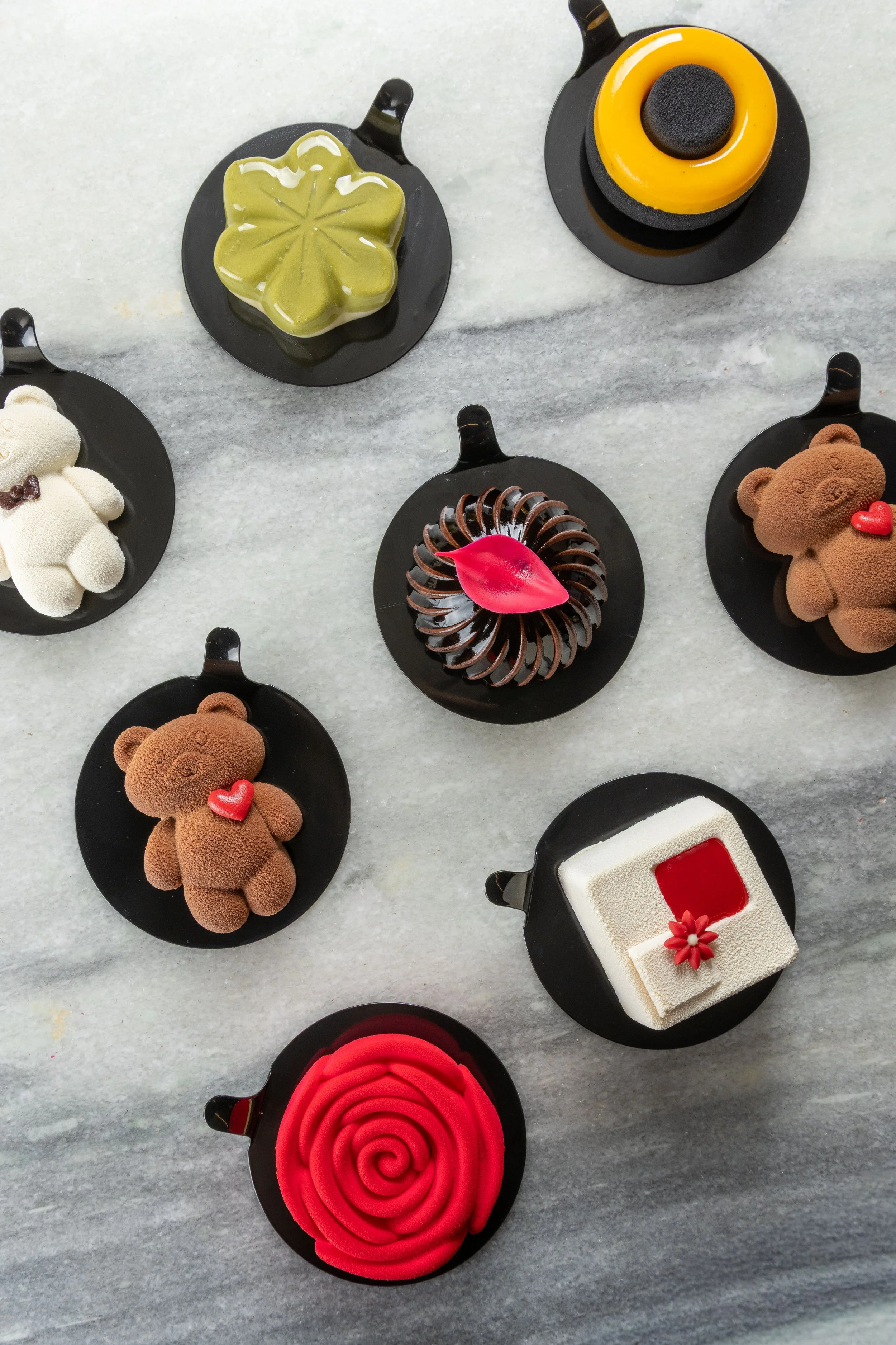 Seleção de doces individuais da Ahto Pâtisserie, com diferentes formatos, cores e acabamentos, produzidos artesanalmente em São Paulo.