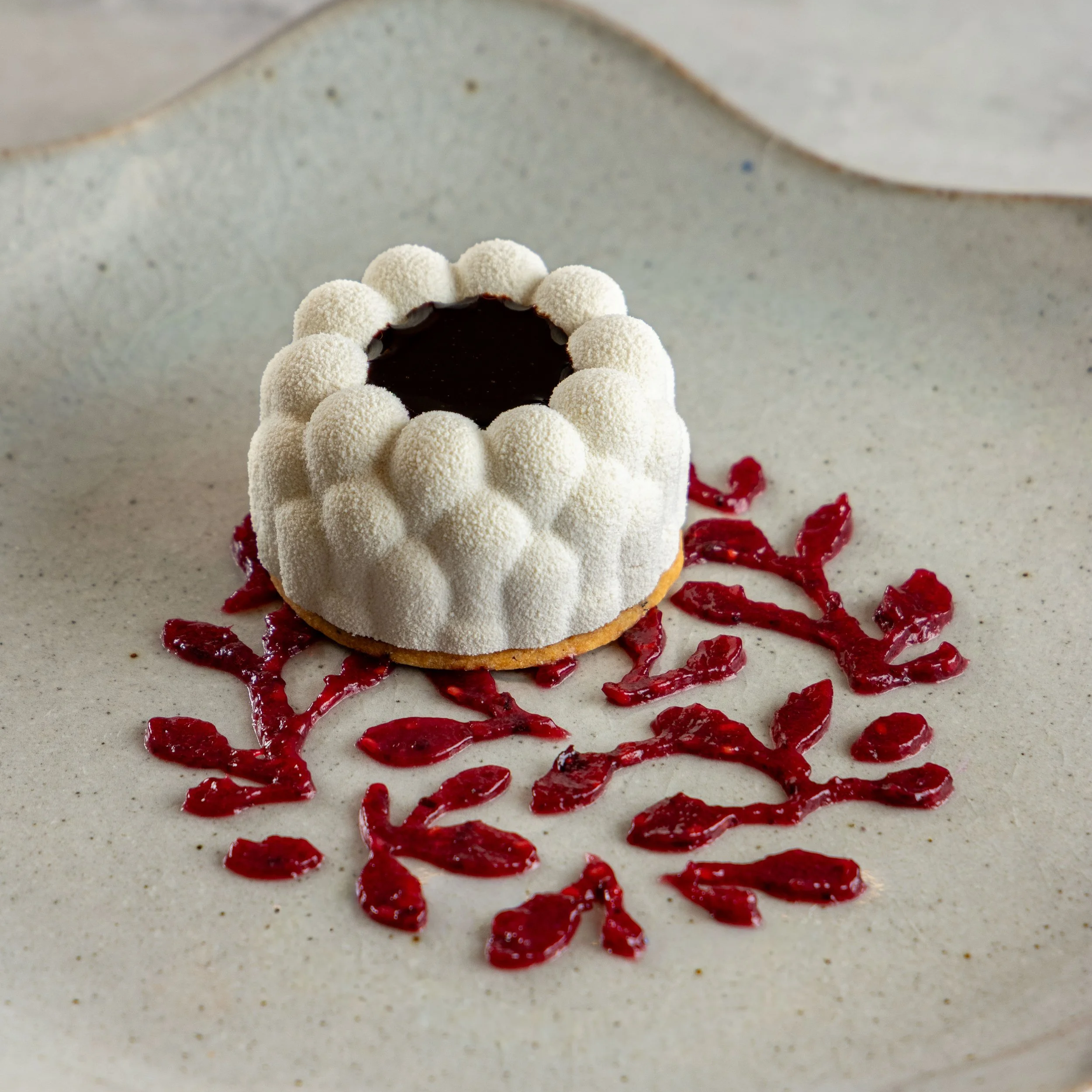 Sobremesa exclusiva desenvolvida pela Ahto Pâtisserie para restaurante, com formato floral, acabamento delicado e apresentação autoral.