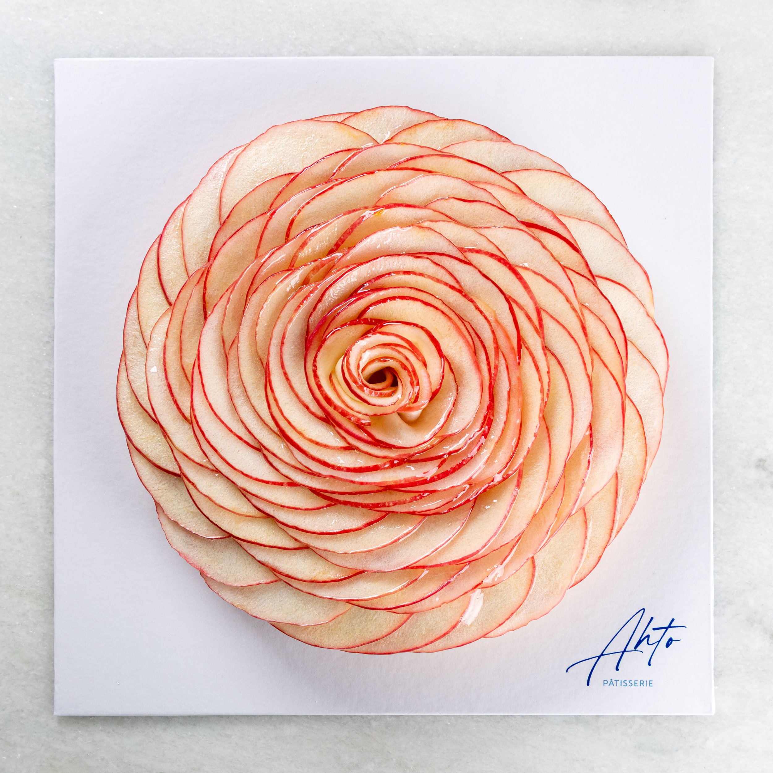 Torta de maçã da Ahto Pâtisserie, decorada com finas lâminas de maçã organizadas artesanalmente em formato de flor.