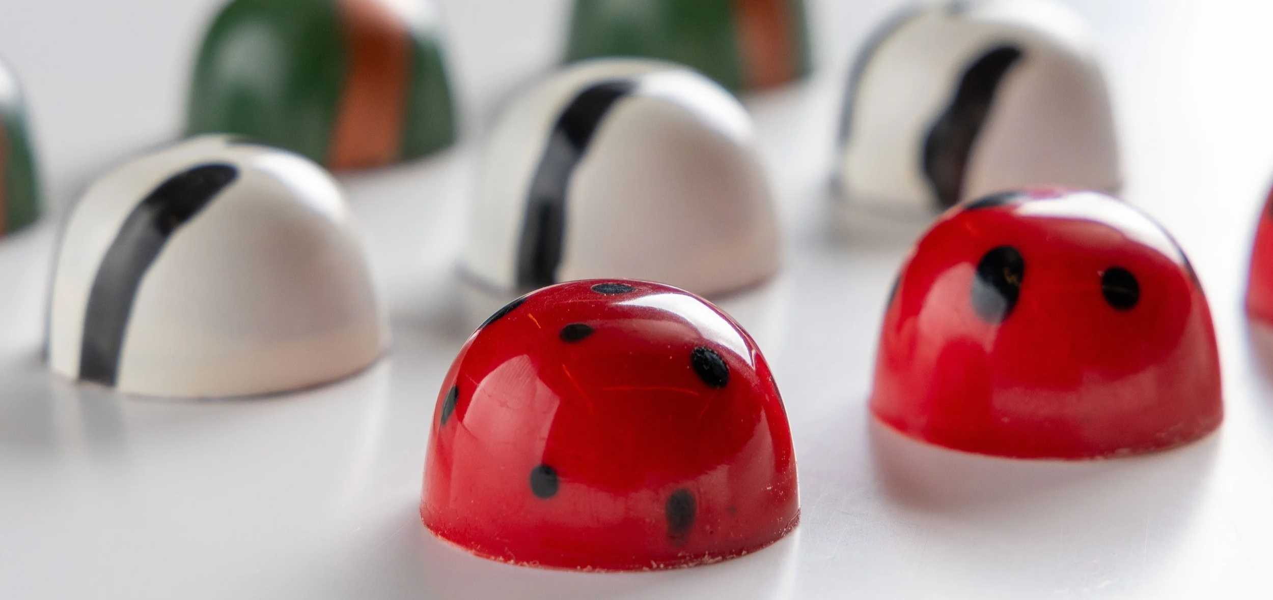 Bombons personalizados da Ahto Pâtisserie, com diferentes formatos e acabamentos em chocolate, desenvolvidos para projetos especiais, empresas e eventos.