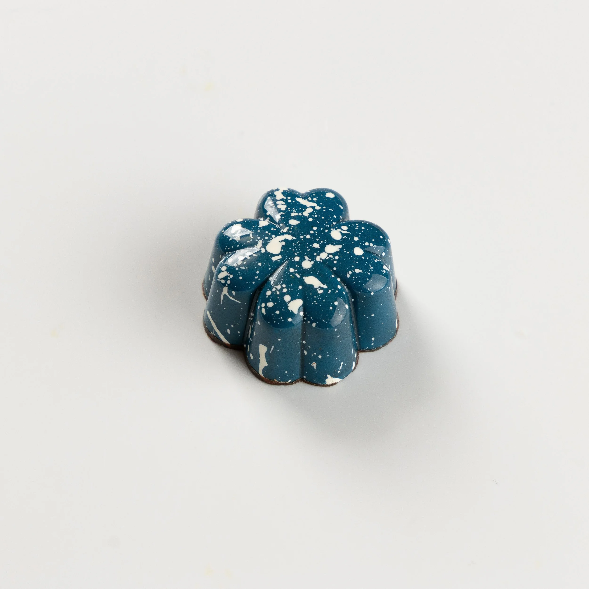 Bombom de chocolate amargo da Ahto Pâtisserie, com acabamento azul.