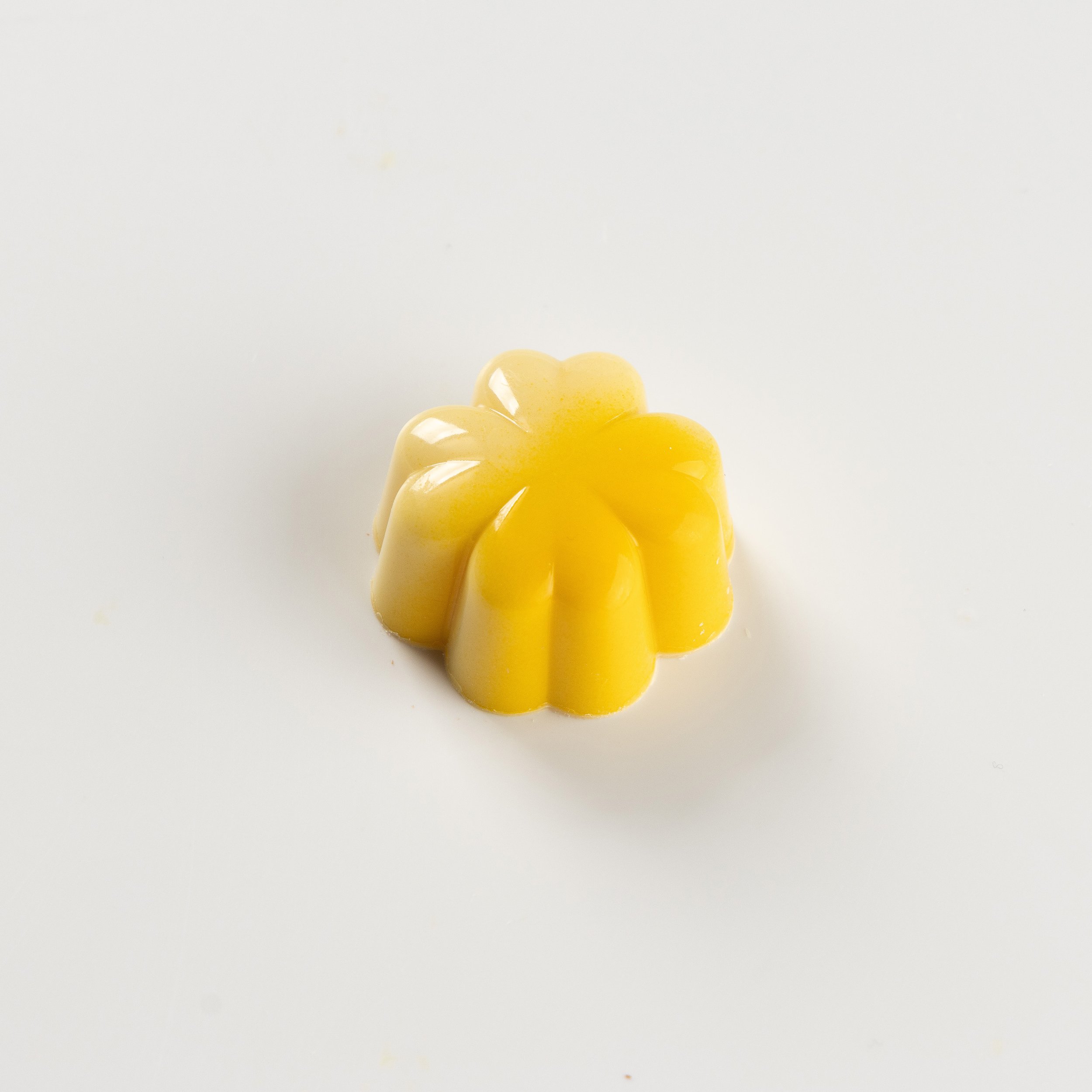 Bombom de limão siciliano da Ahto Pâtisserie, com acabamento amarelo.