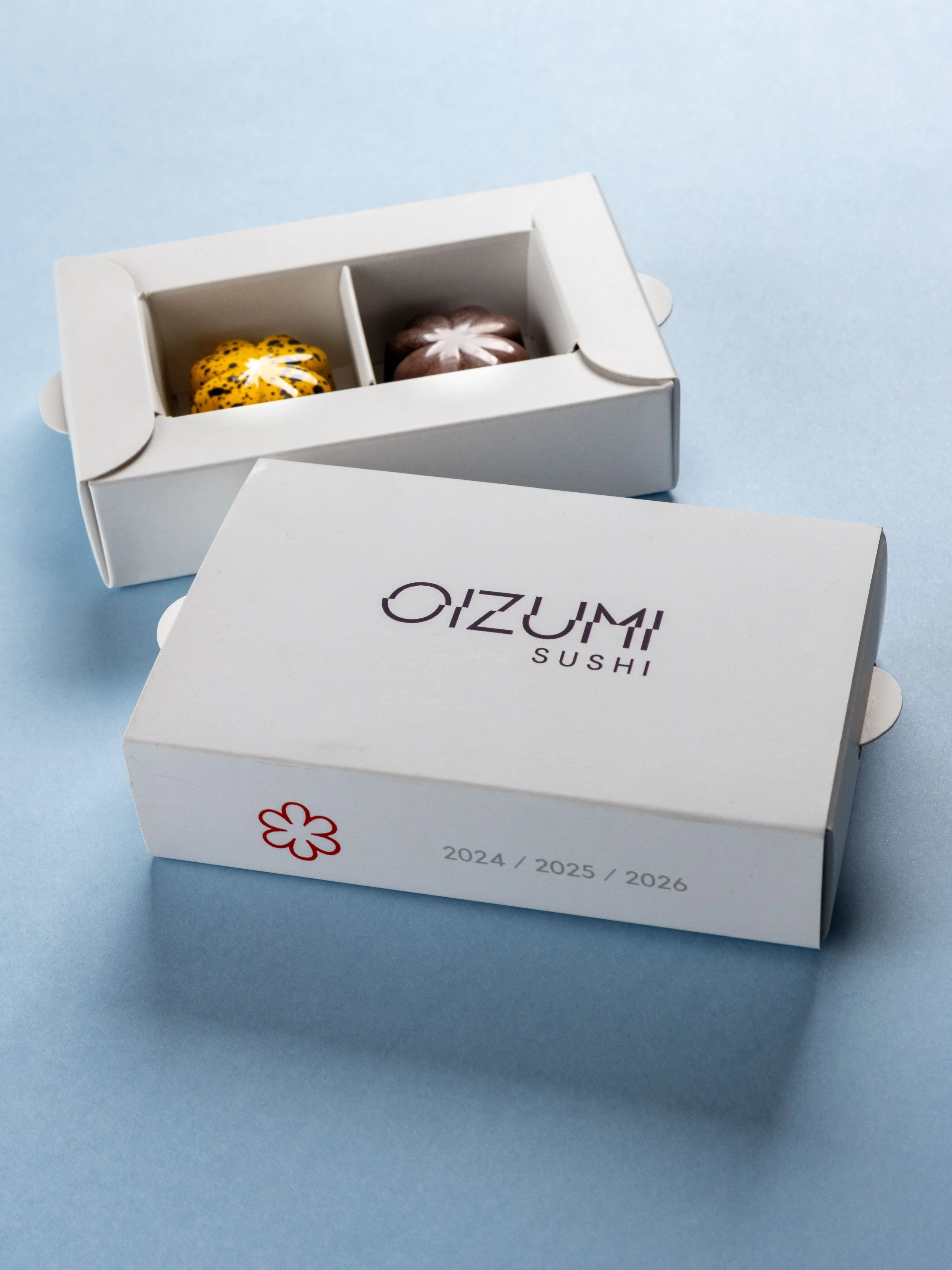 Caixa personalizada criada pela Ahto Pâtisserie para o restaurante Oizumi, exemplo de projeto de bombons e macarons para empresas e eventos.
