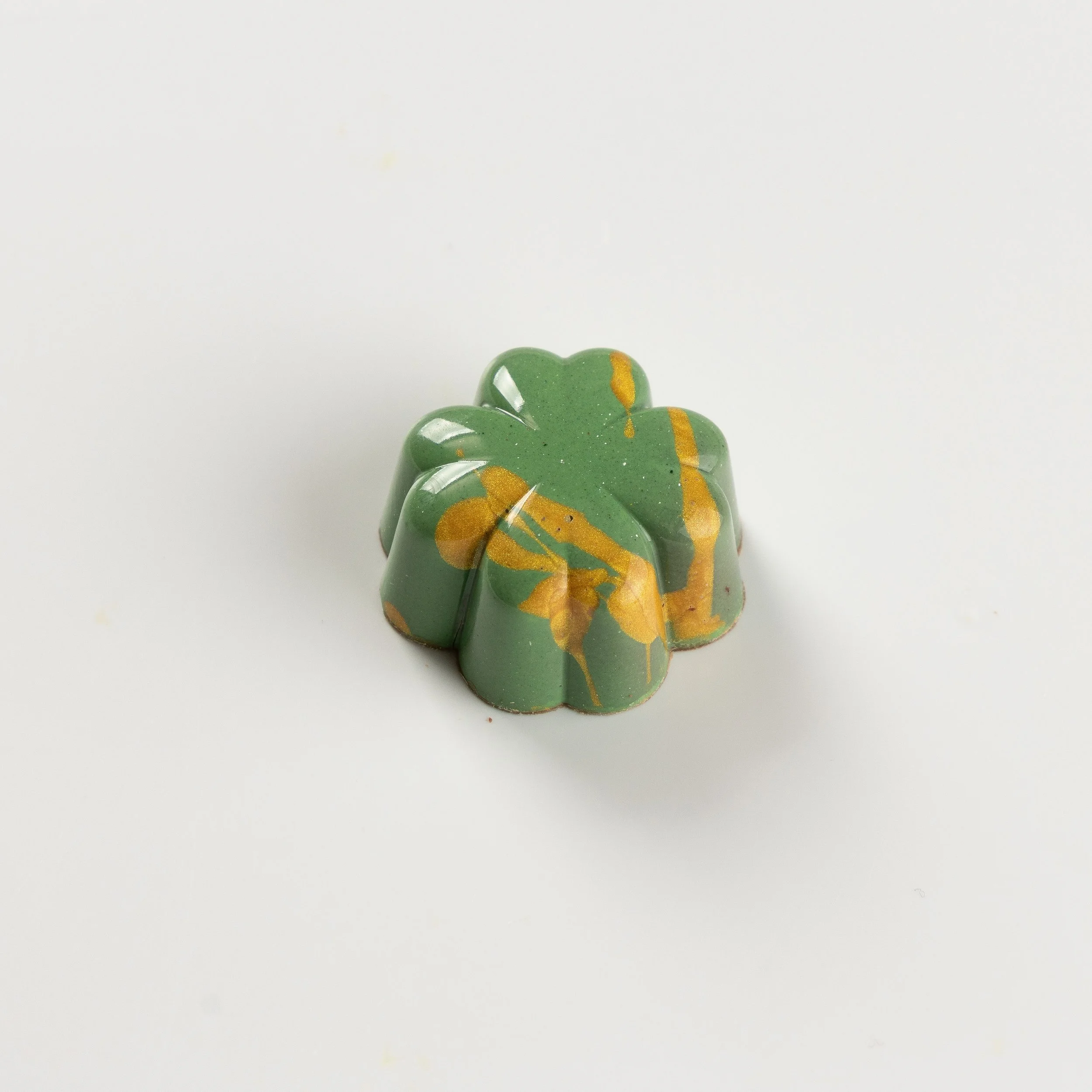 Bombom de wasabi da Ahto Pâtisserie, com acabamento verde e detalhes amarelos.