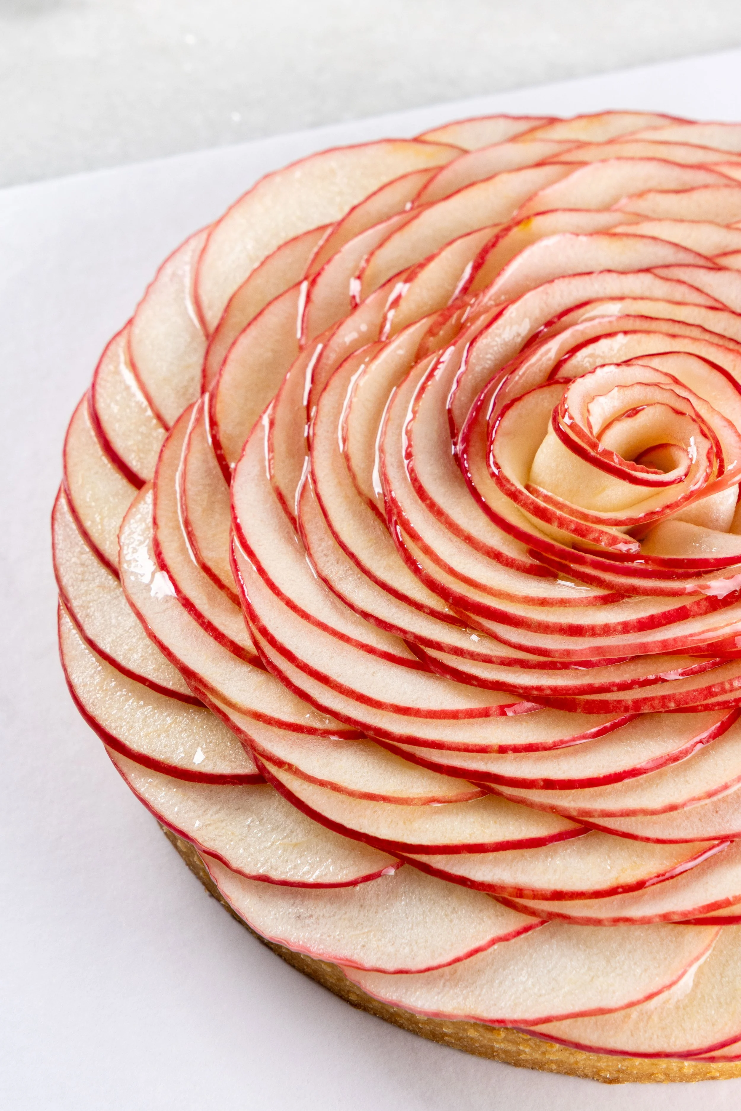 Torta de maçã da Ahto Pâtisserie, finalizada com finas lâminas de maçã dispostas em formato de flor.