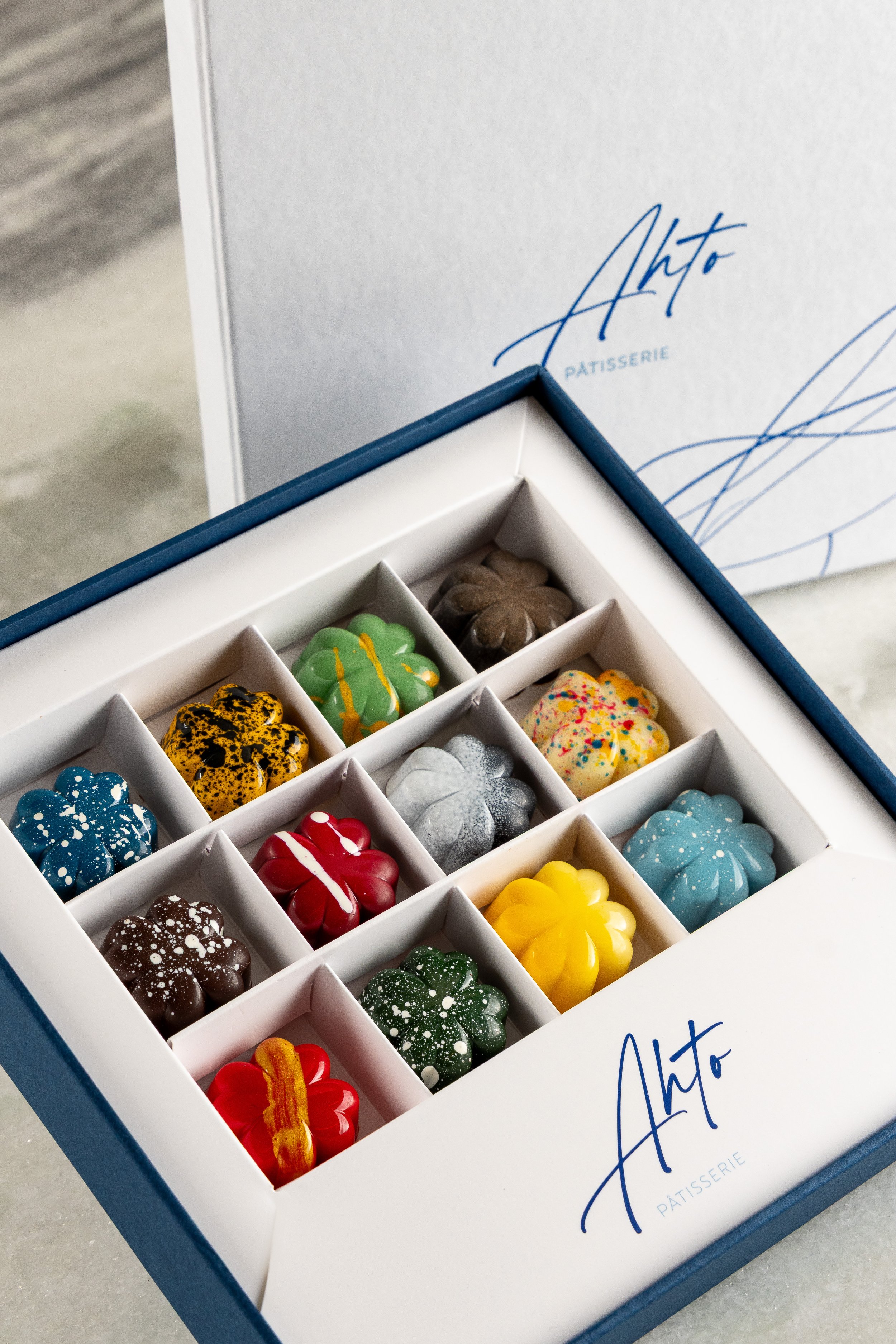 Caixa de bombons artesanais coloridos da Ahto Pâtisserie, parte da seleção de bombons e macarons produzidos em São Paulo.