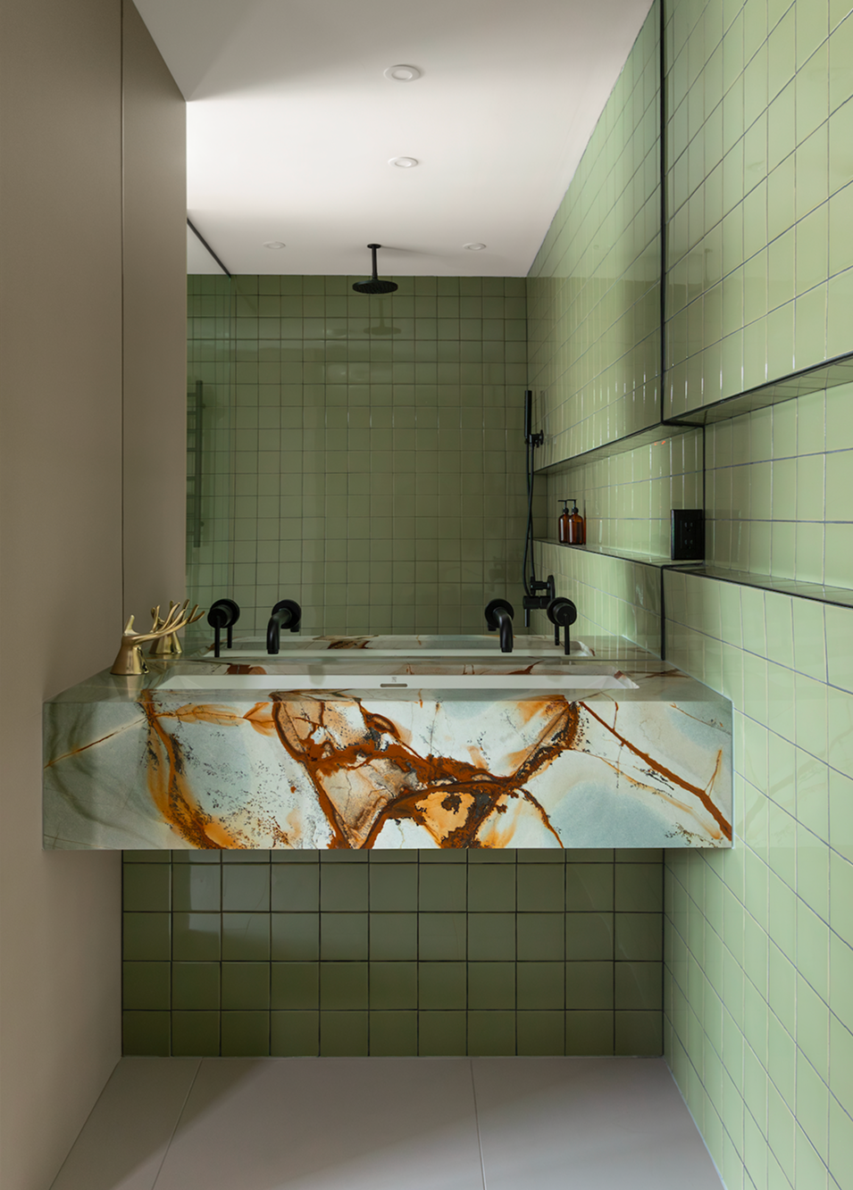 Modern bathroom with green tiled walls, a marble sink countertop with orange, white, and gray patterns, black fixtures, and a rain showerhead.