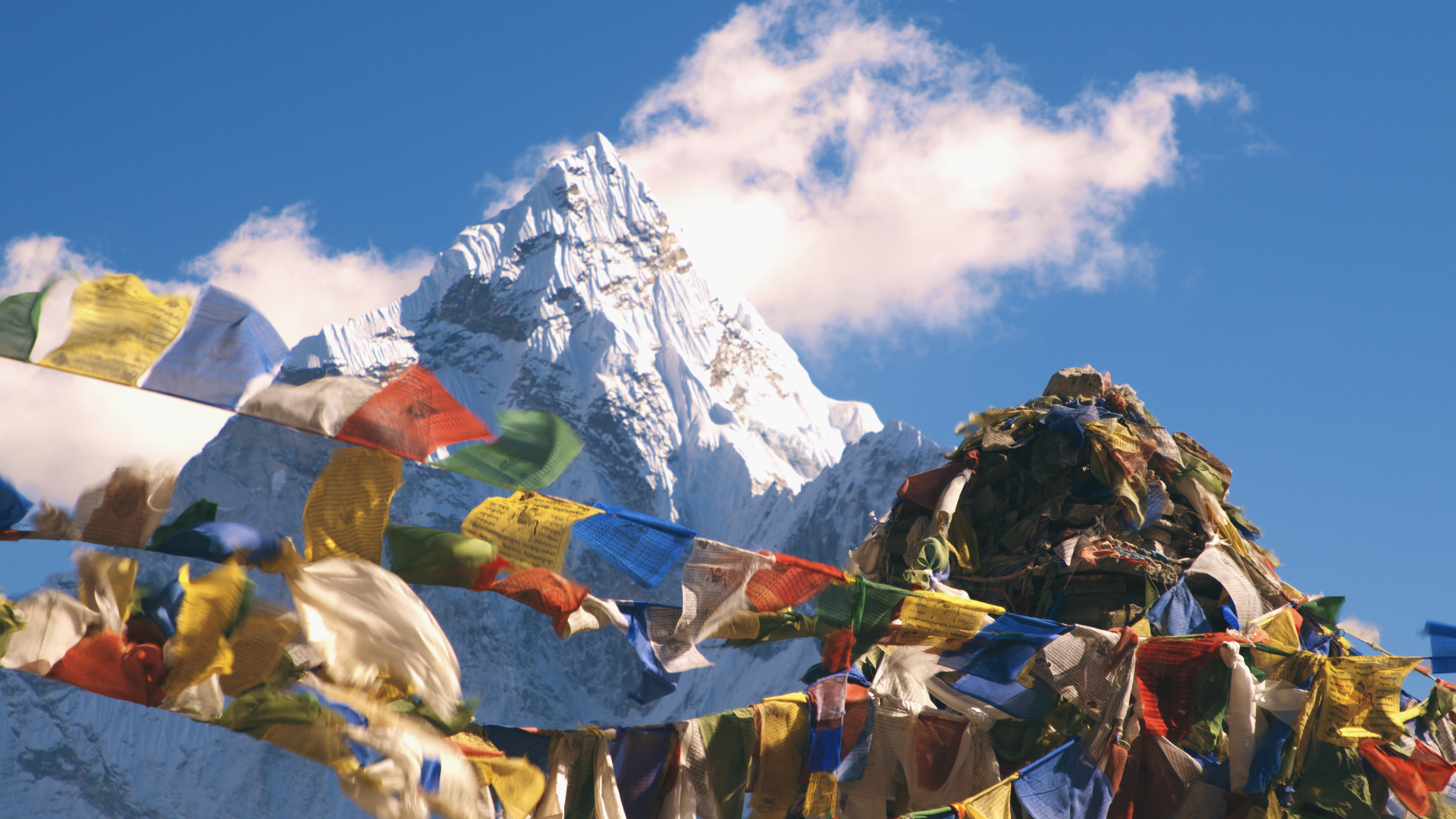 Drapeaux à prières bouddhistes devant un sommet himalayen