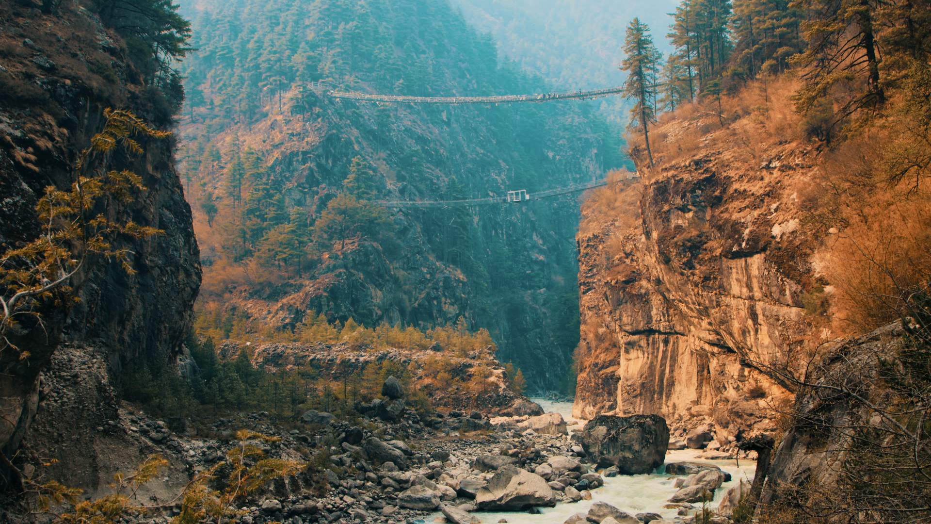 Pont suspendu entre deux montagnes et rivière