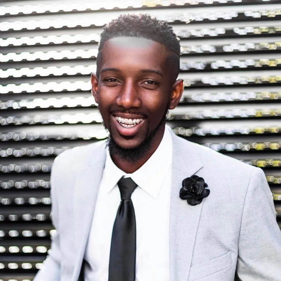WJ Daggins smiling in a white suit and dark tie