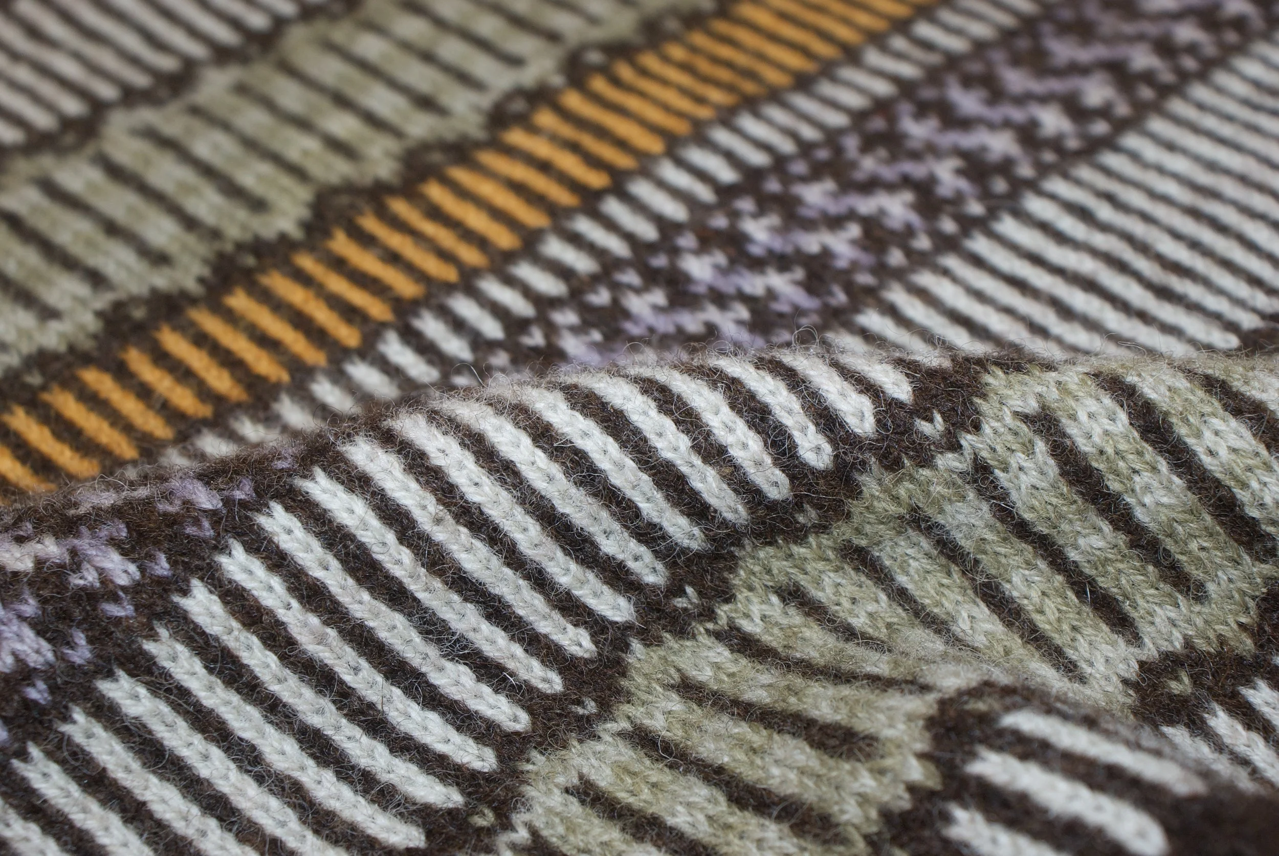 Close-up of striped, woven fabric with horizontal lines in shades of brown, beige, white, and orange.