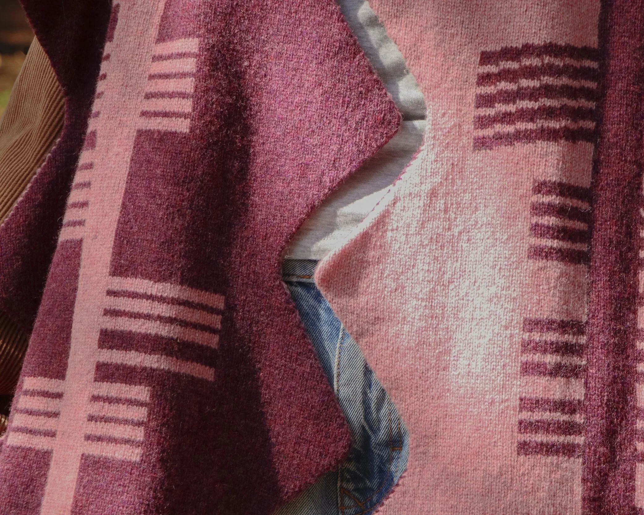 Close-up of a person wearing a pink and purple ogham scarf.