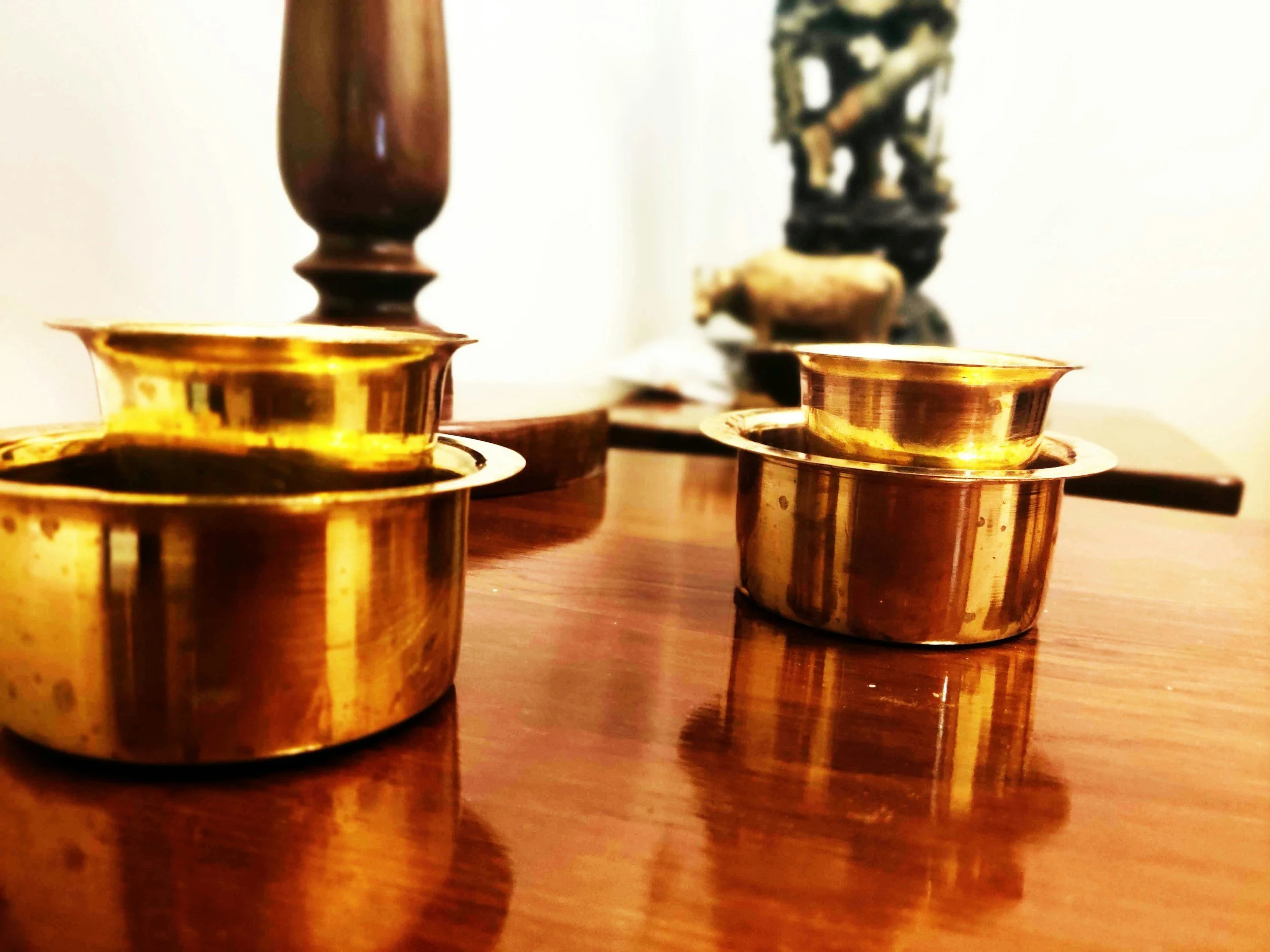 Polished brass tableware on a wooden table
