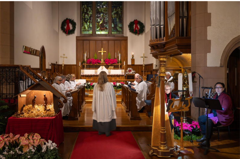 Christmas Eve church service with choir, altar, nativity display, harpist, and organ in a decorated sanctuary