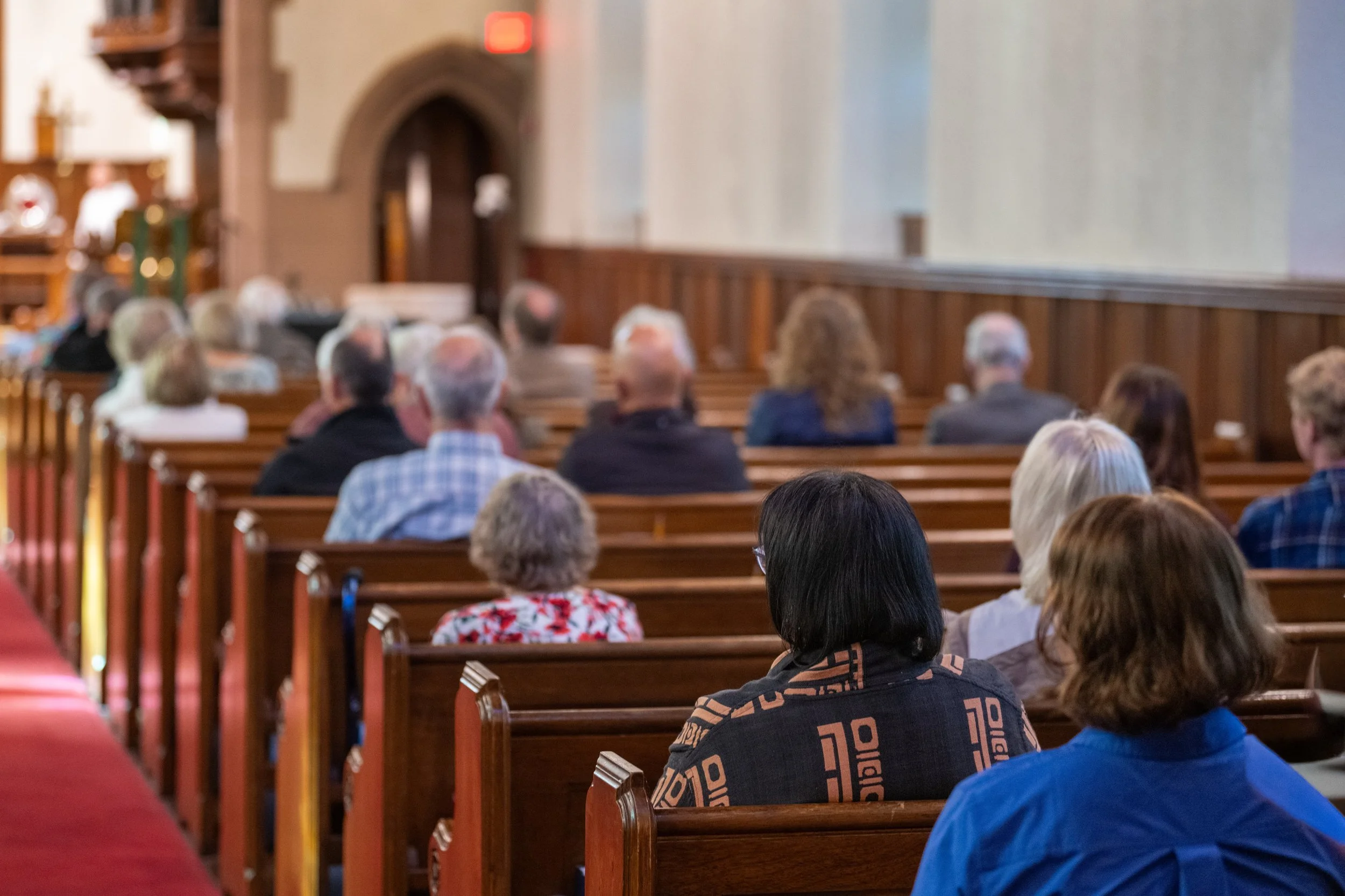 Congregation seated in wooden church pews during a service