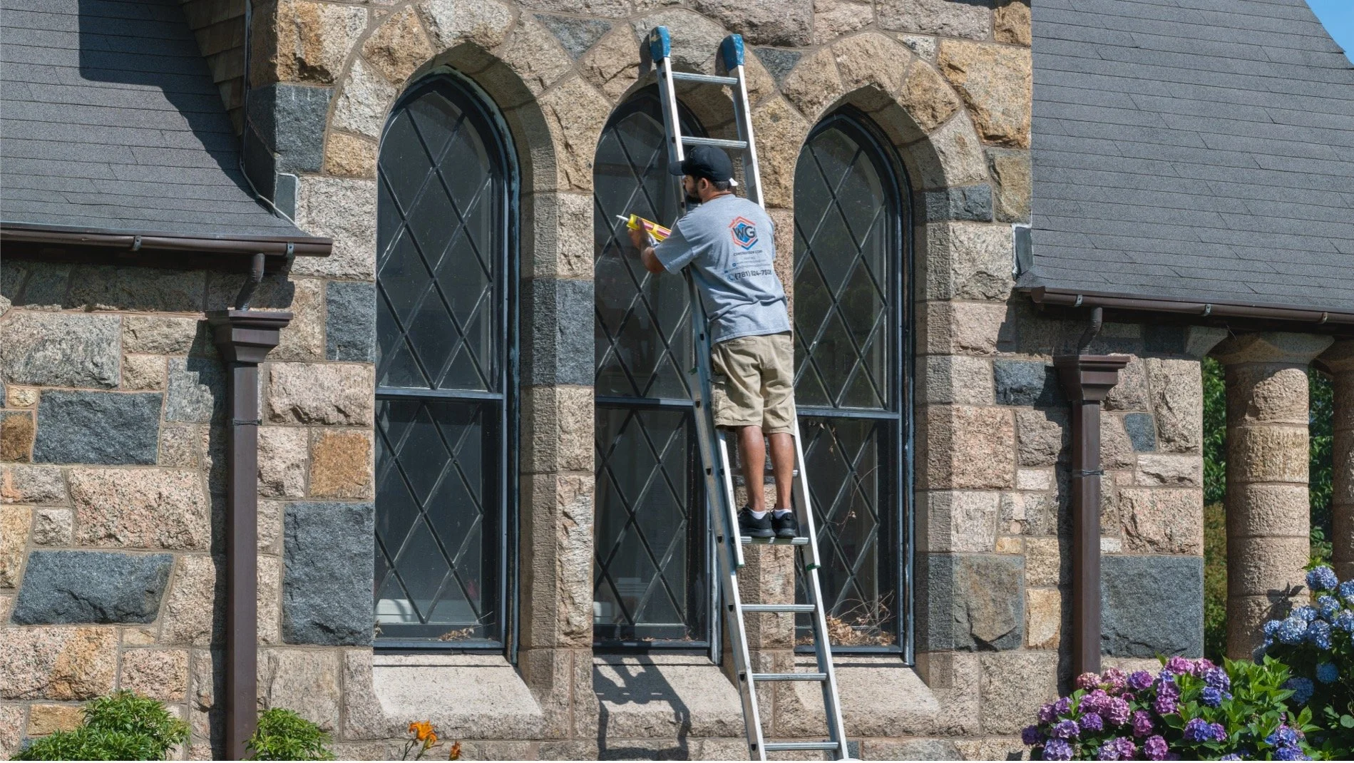The grounds committee is cleaning our arched church windows in a stone building