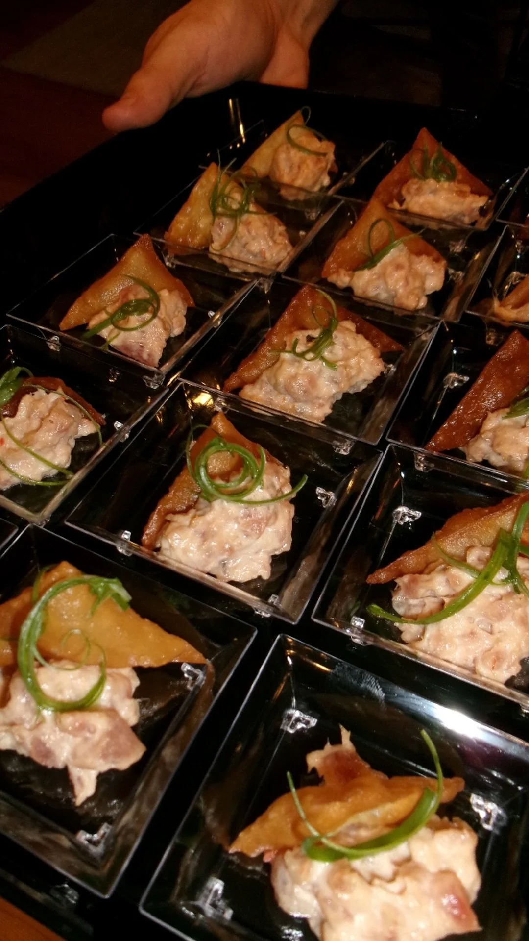 Multiple small appetizer servings in glass dishes with a creamy topping and green garnish.