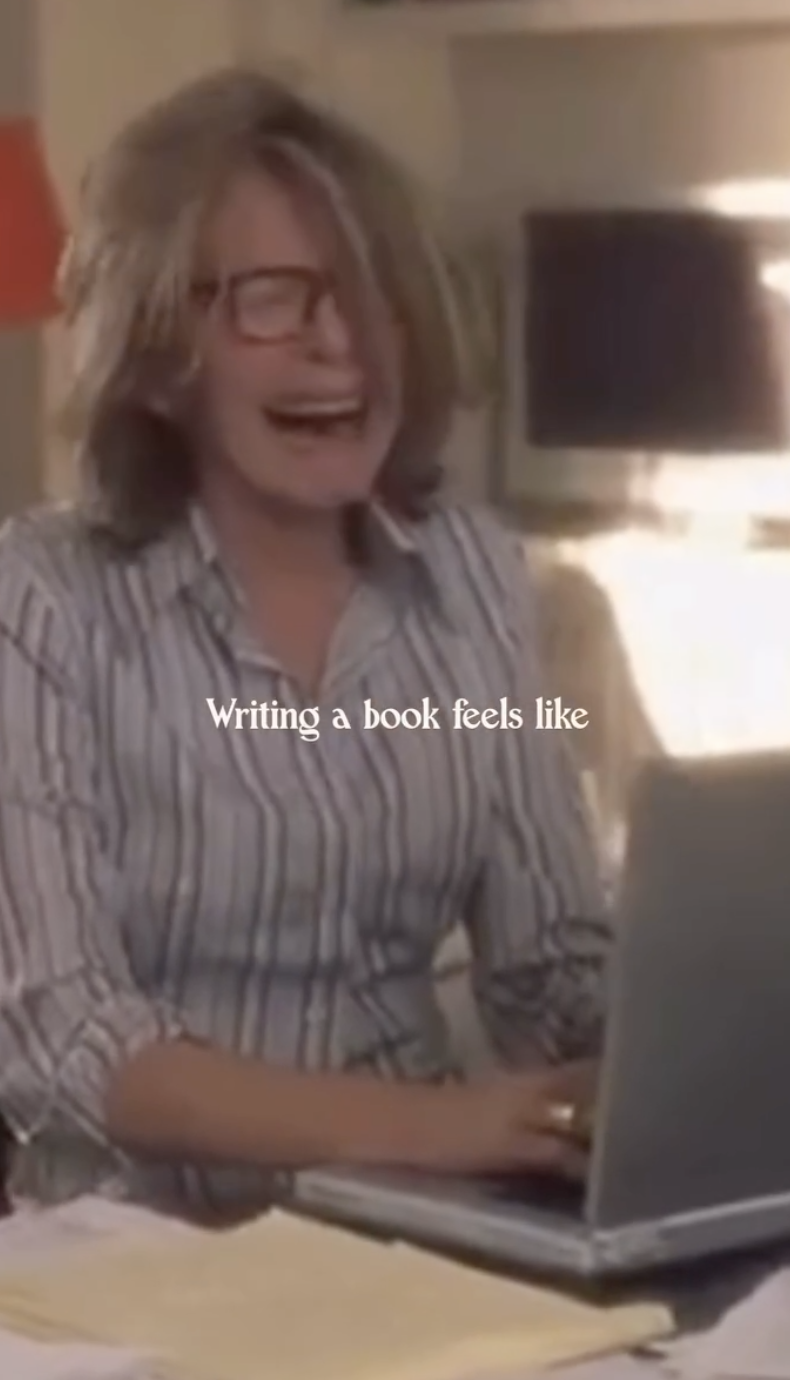 Person wearing glasses smiling while working on a laptop, with text "Writing a book feels like" on the image.