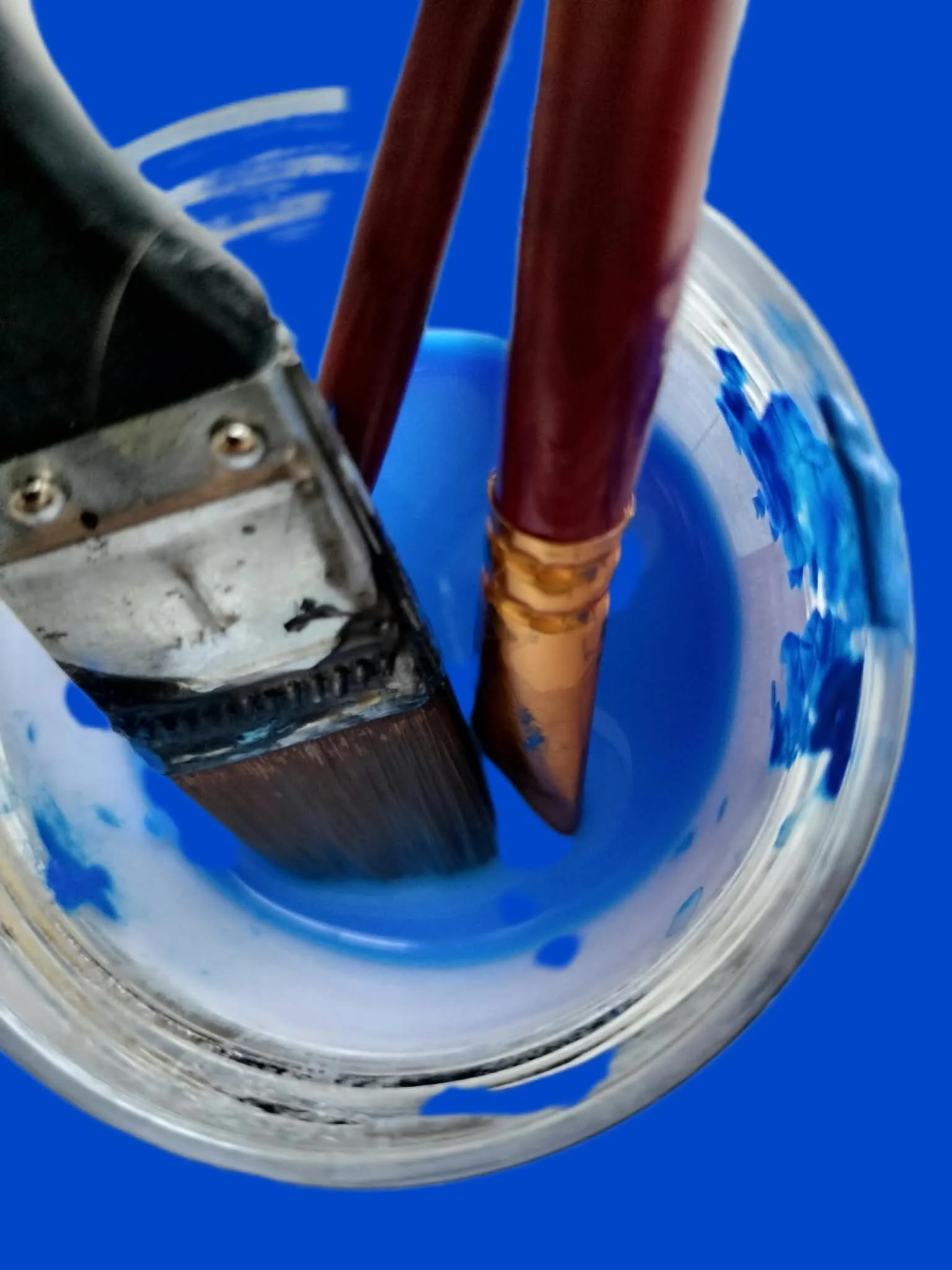 Pinceaux dans un pot d'eau cobalt