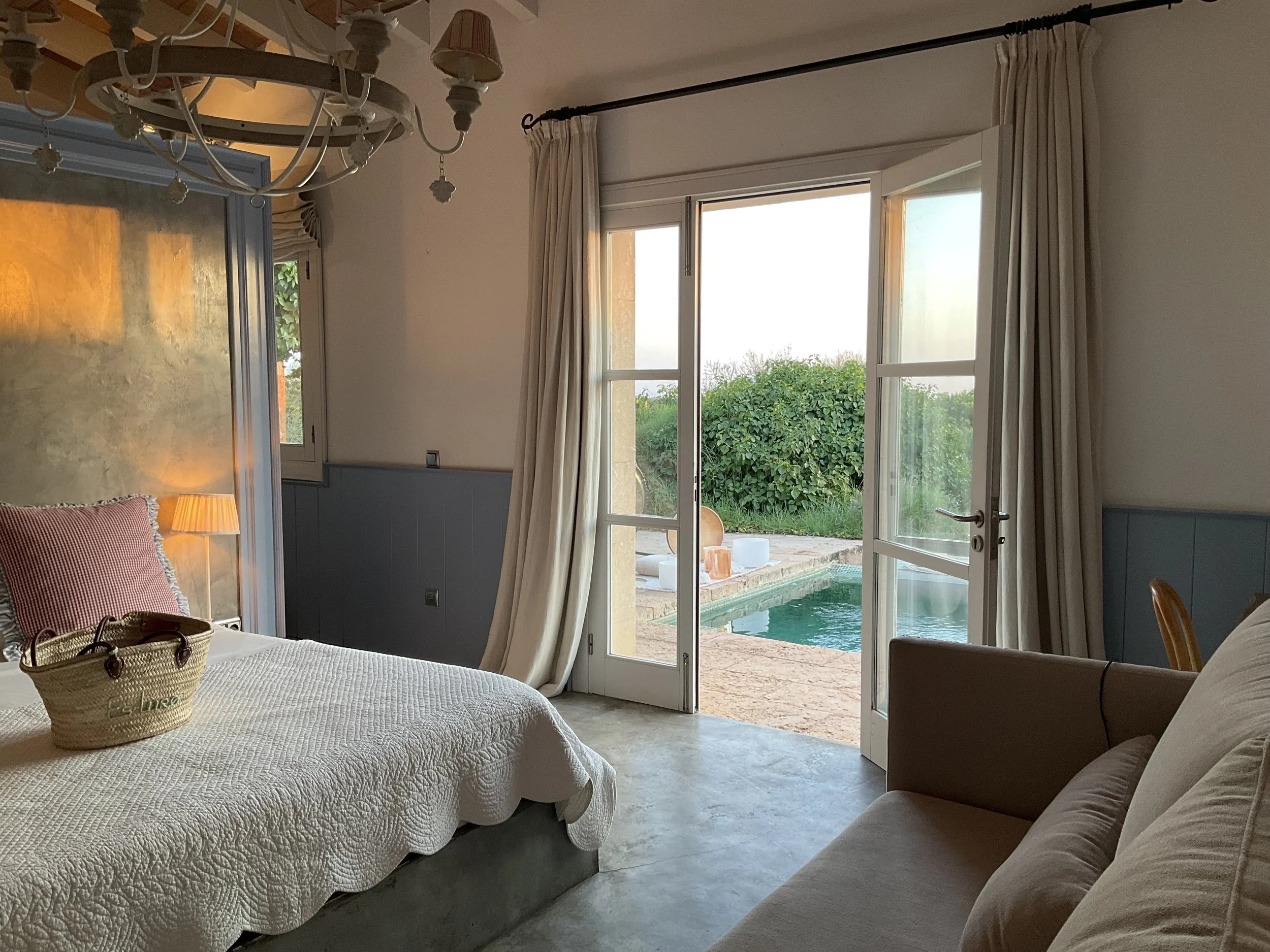 Hotel suite bedroom with doors open onto a private pool, ready for an in-suite floating sound bath