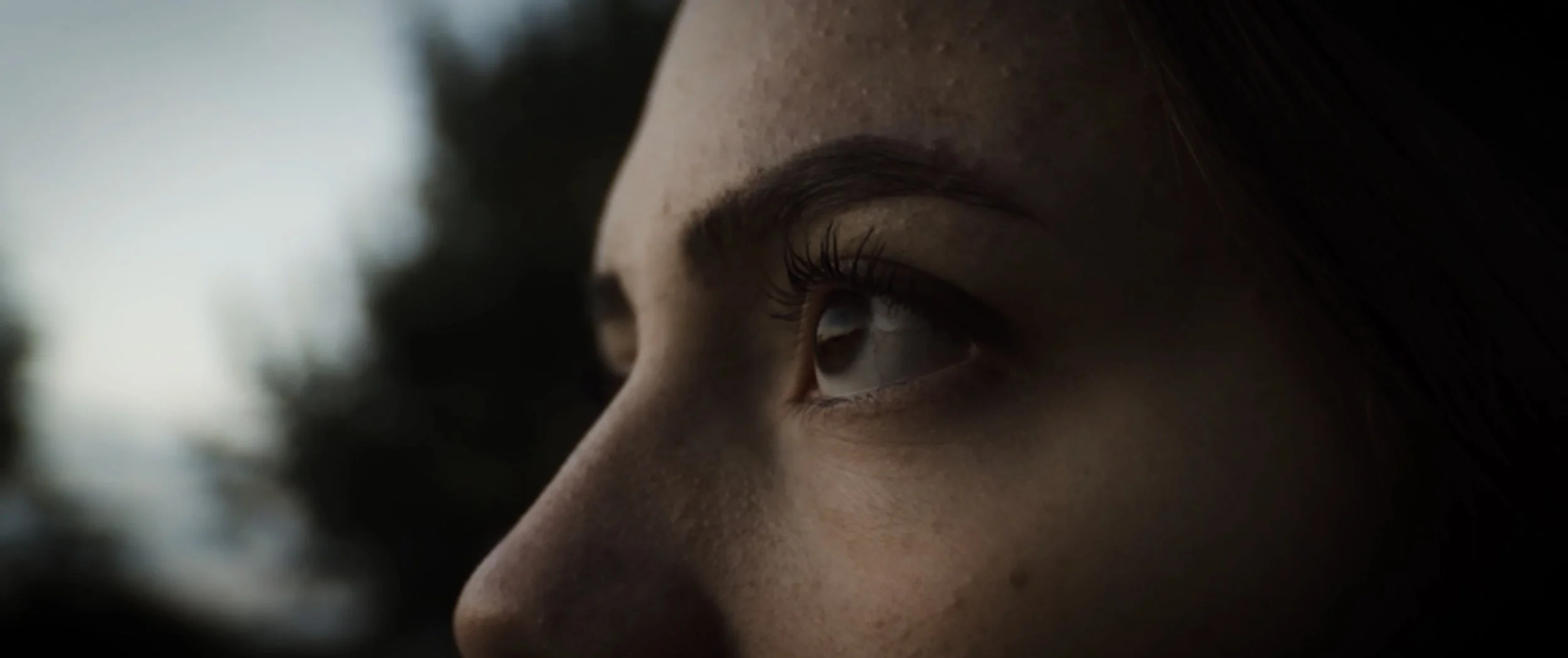 Cinematic Video Close-up of a girl's face, focusing on her right eye, with dark hair and natural lighting.