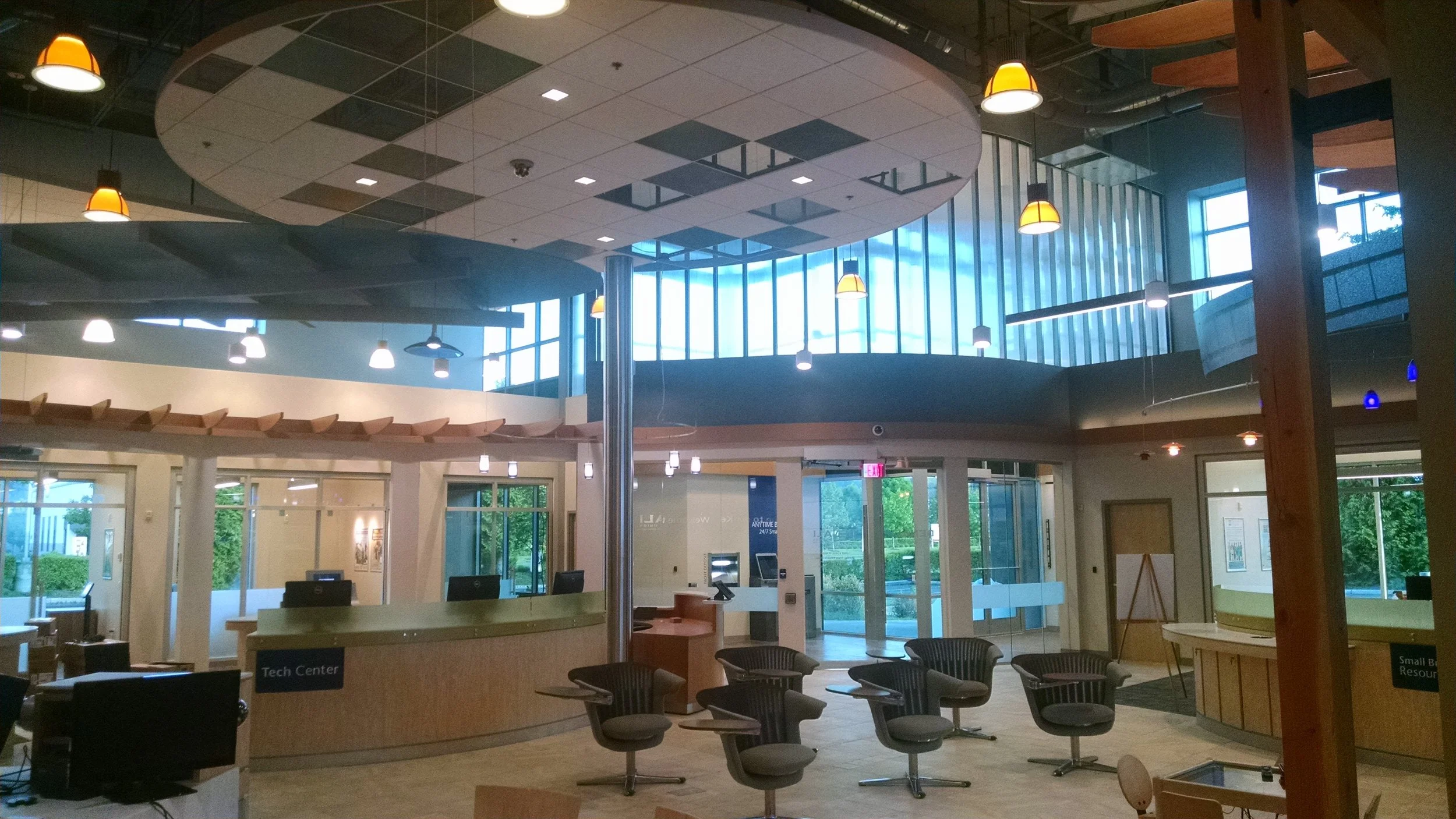 Interior of a commercial property with reception area, seating, large windows, and visible building systems.