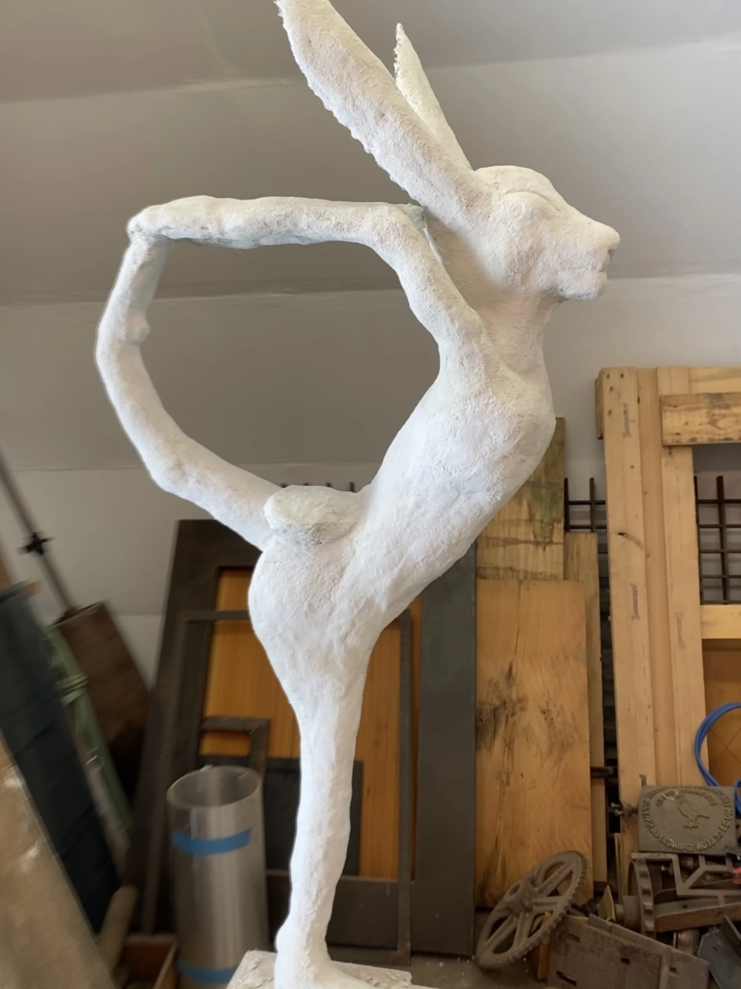 A hare in a yoga pose taking shape in the studio, one of three in a series.