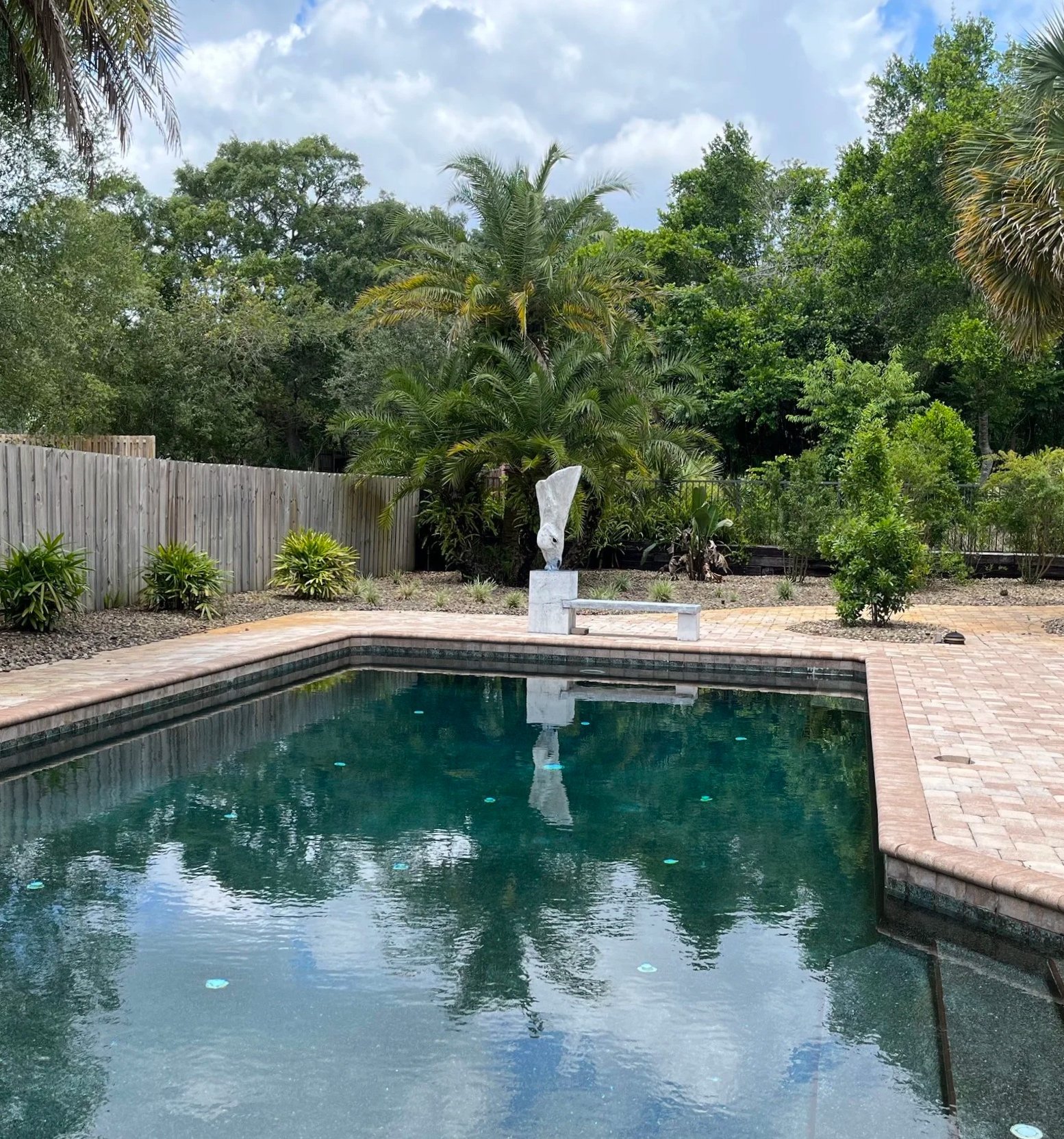The finished horse, 'Ollie," and bench installed at the edge of a pool. Hand-formed artisan cement over a steel armature.