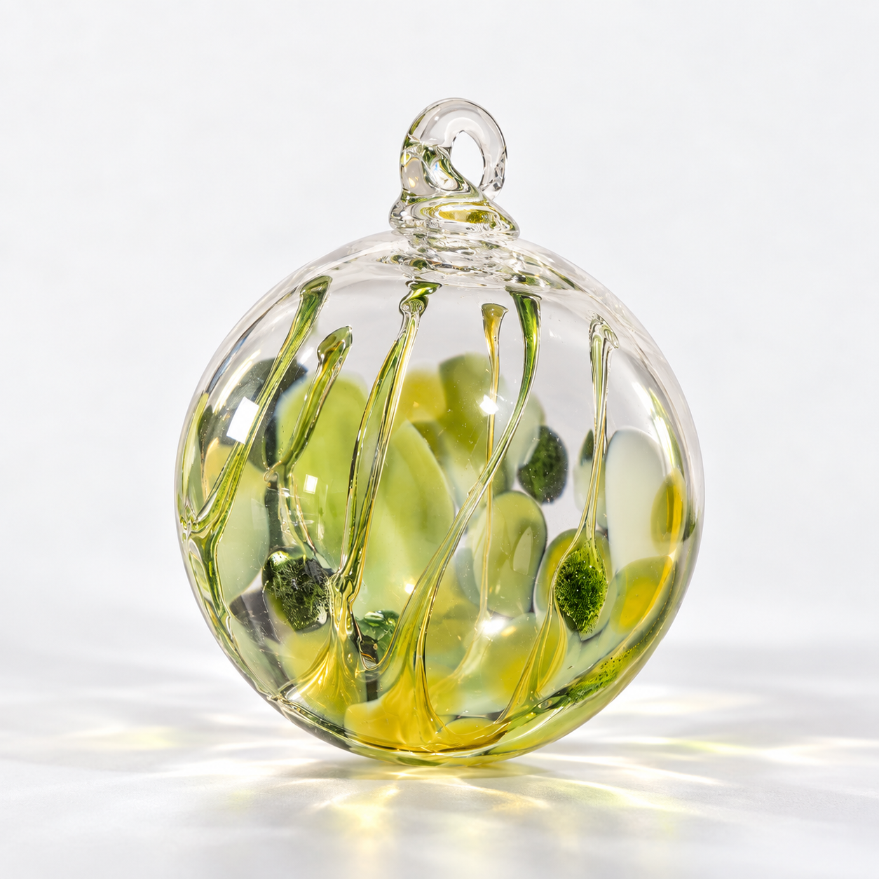 A decorative glass orb with yellow and green details inside.