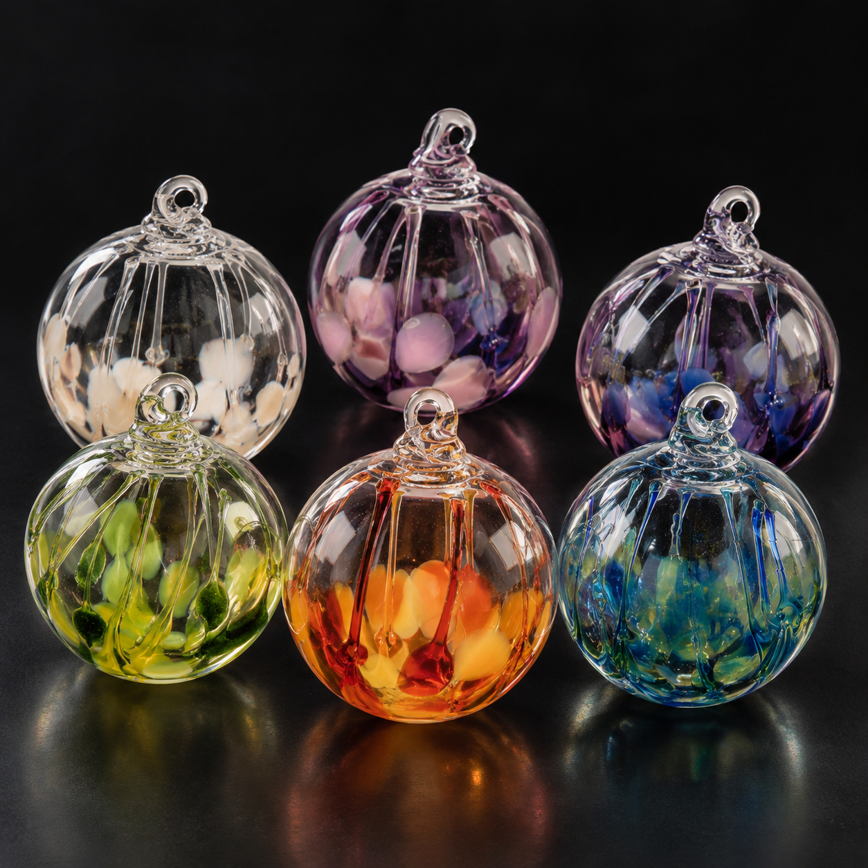 Six colorful glass Christmas ornaments with swirling patterns on a black background.