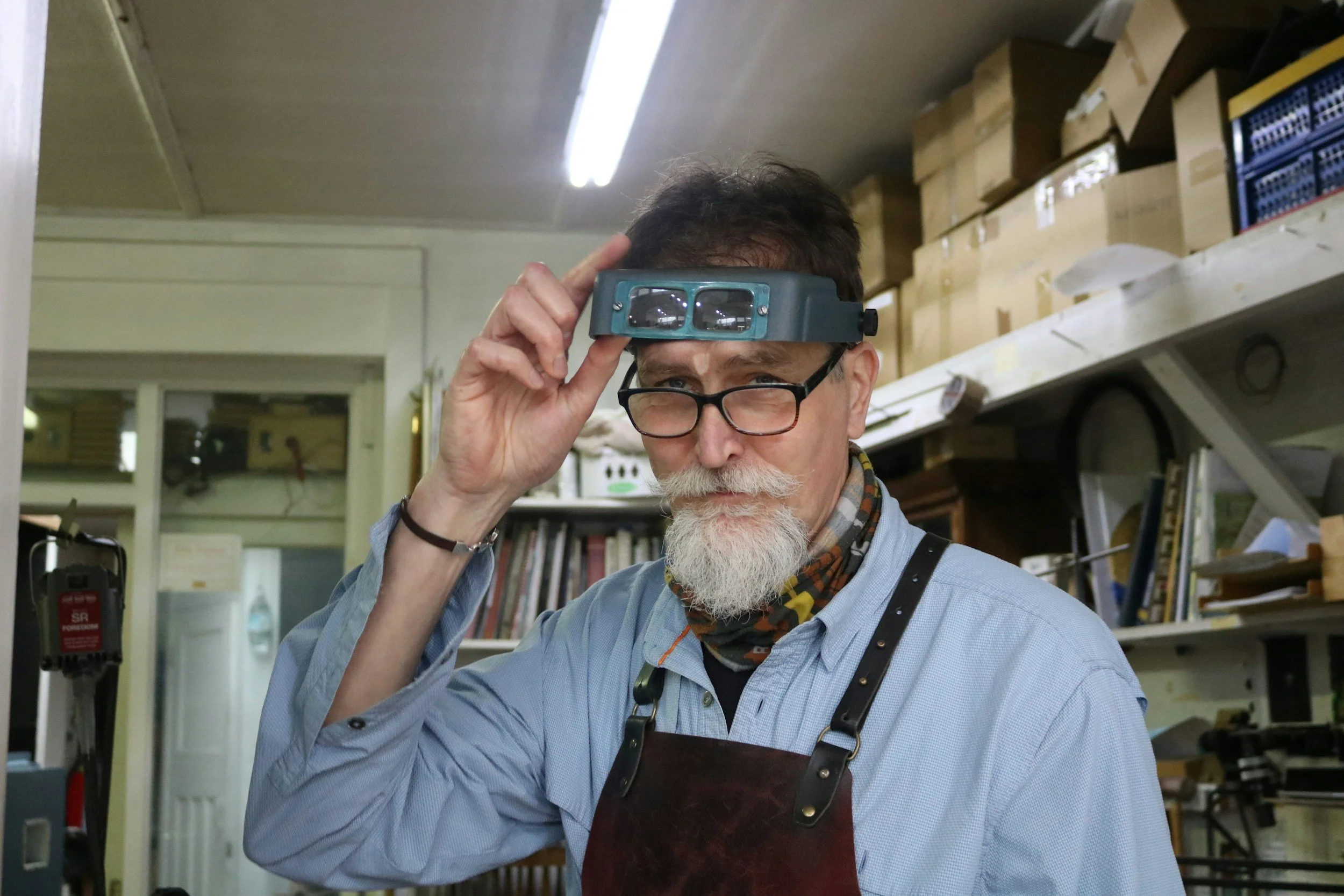 Leatherworker inspecting a project in the workshop.