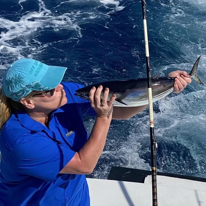 Angler celebrating a small catch aboard Cool Breeze