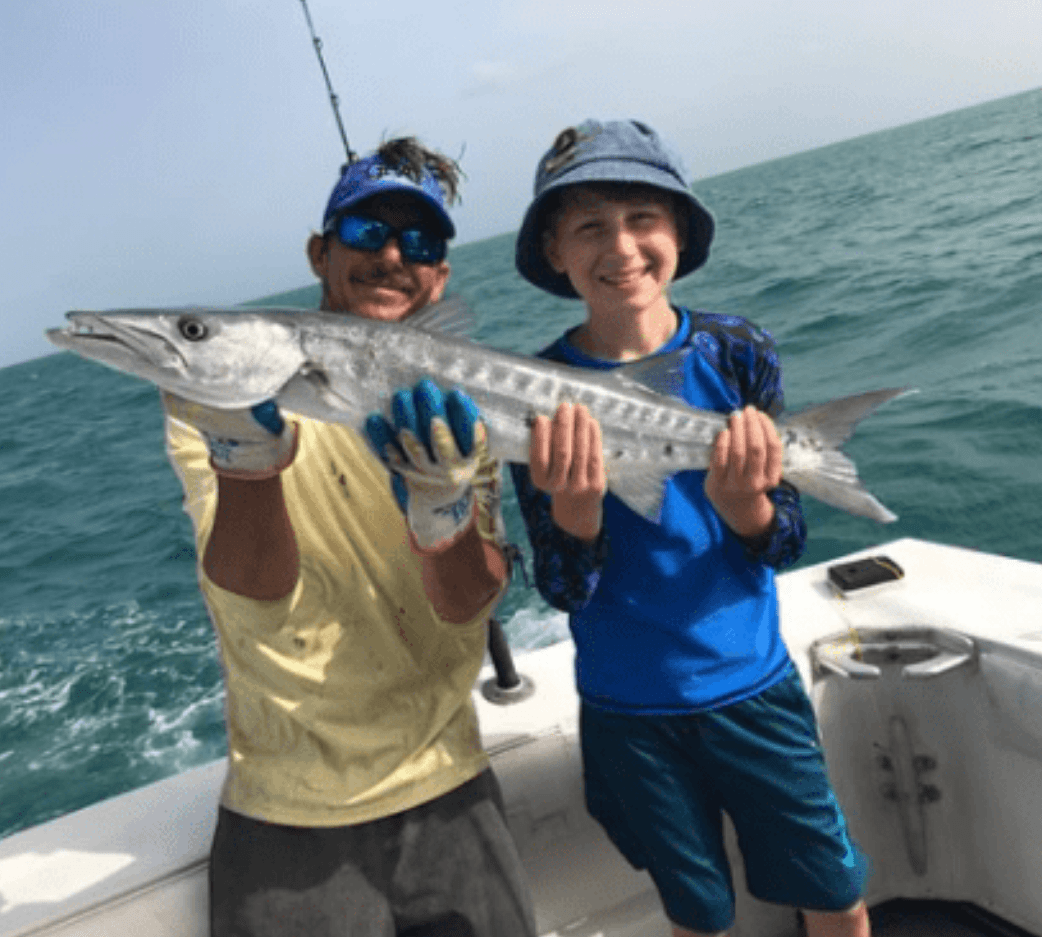 Two anglers aboard Cool Breeze holding a barracuda catch
