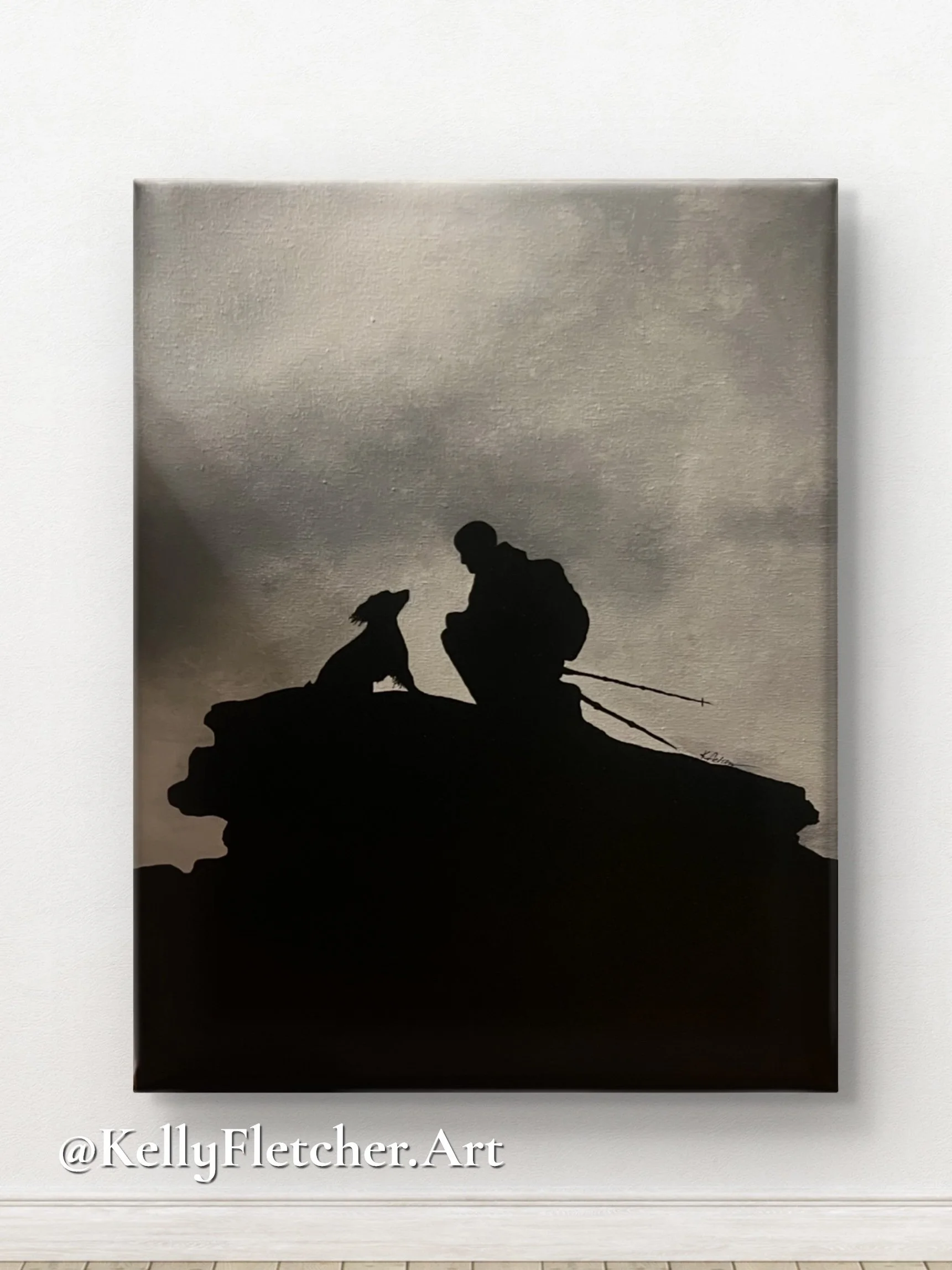 Silhouette of a person kneeling on a rocky outcrop, reaching out to a dog during sunset with a cloudy sky.
