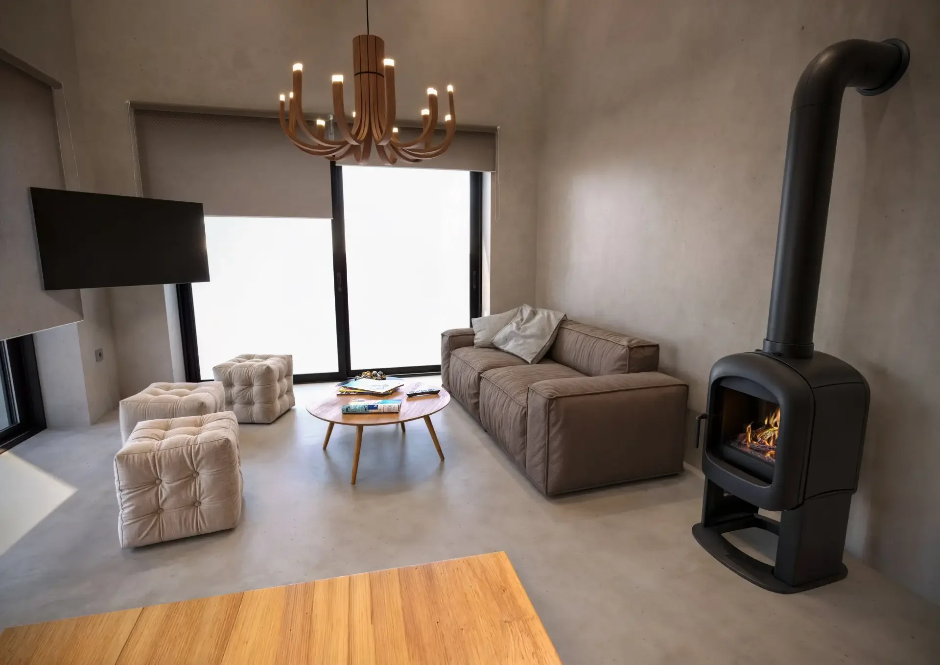 3D render καθιστικού με μοντέρνα σόμπα, γήινους τόνους και ξύλινο πολυέλαιο.