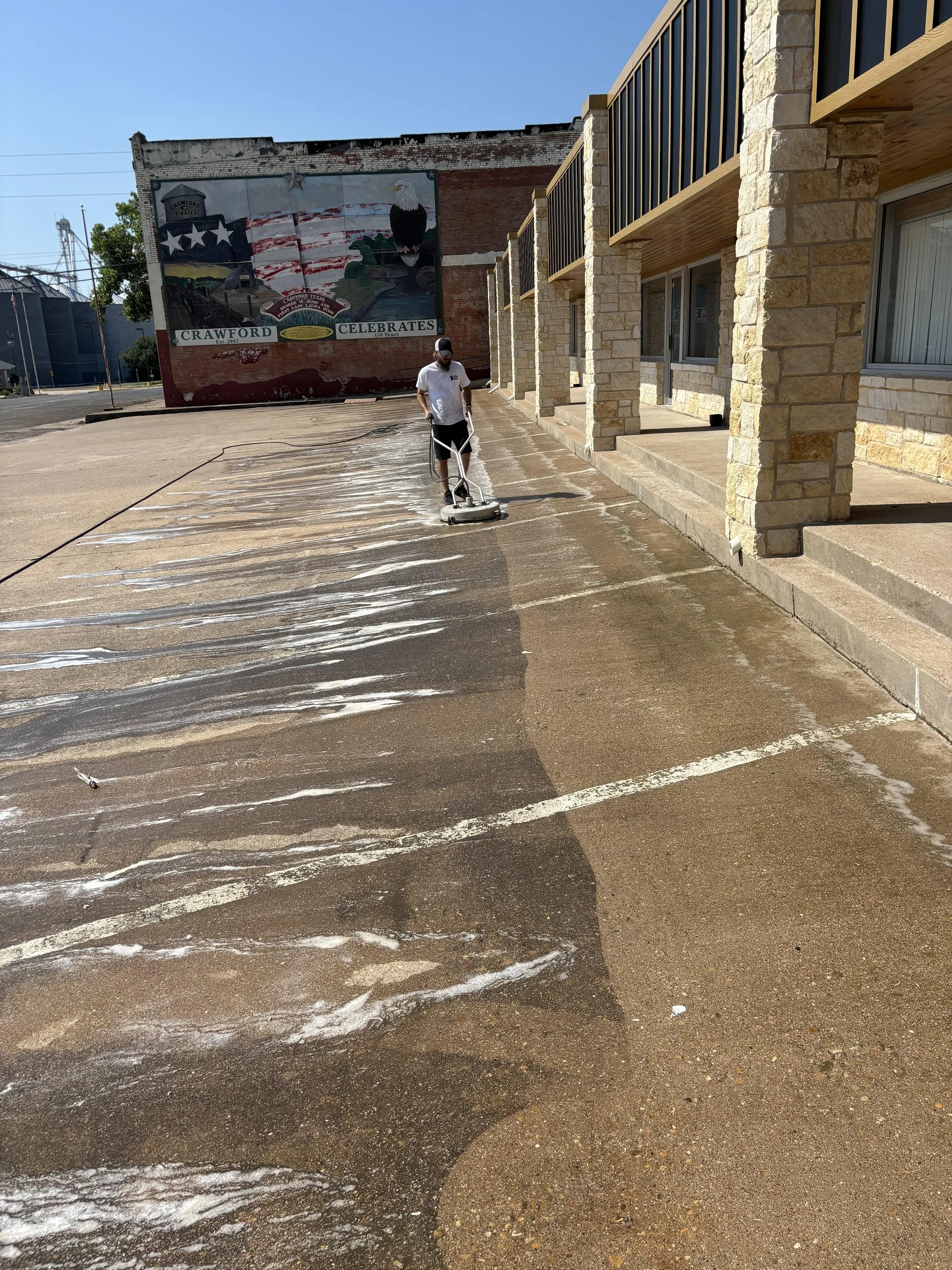 TBS Power Washing using a surface cleaner to effectively wash a commercial parking lot in Georgetown Texas